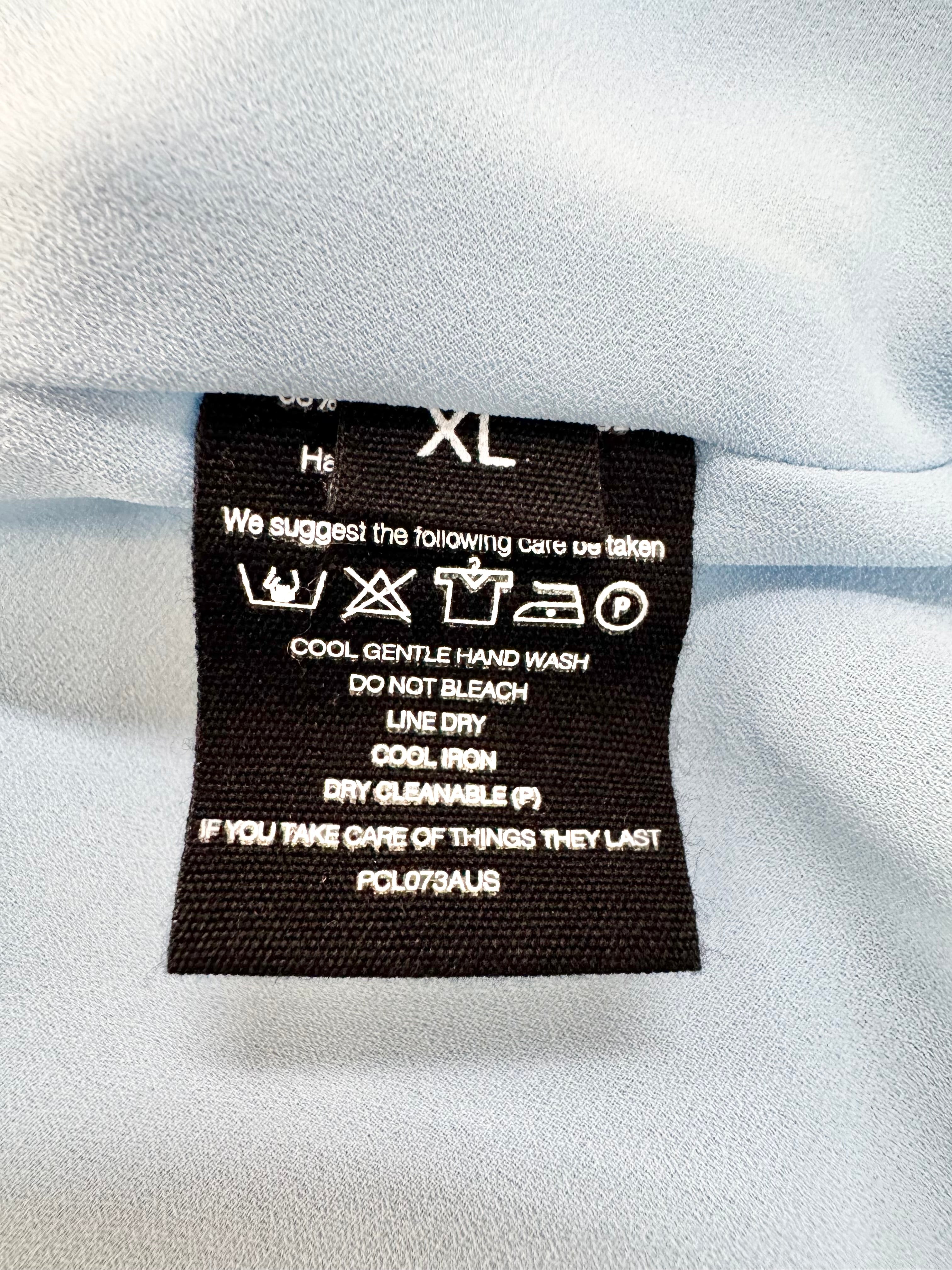 Clothing label with care instructions on a white fabric background