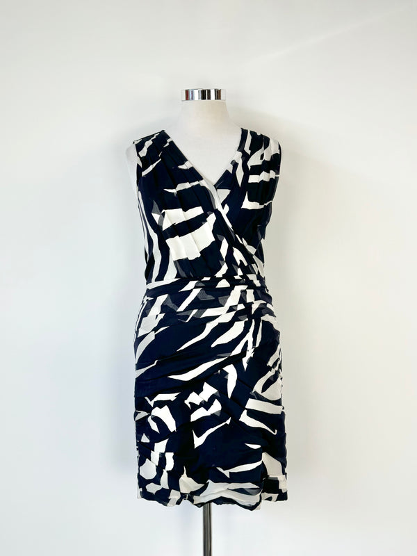 A DKNY black and white patterned dress displayed on a mannequin, featuring a sheer deep navy and shell white design with a black panel back.