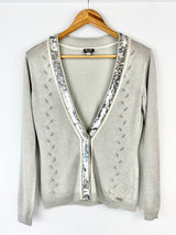 Gray cardigan with sequin details on a hanger against a white background