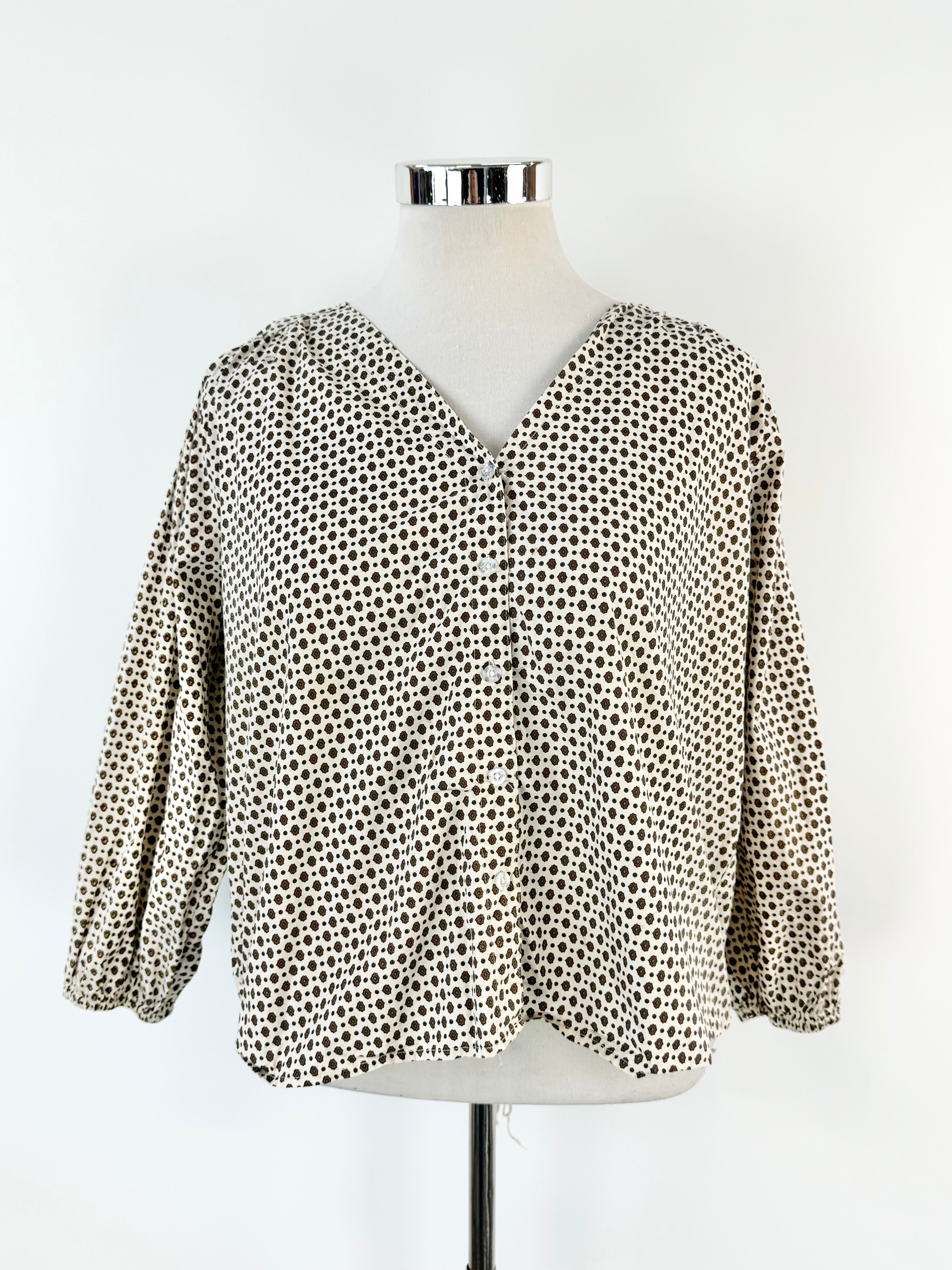 A beige and white patterned cotton blouse displayed on a mannequin against a white background.