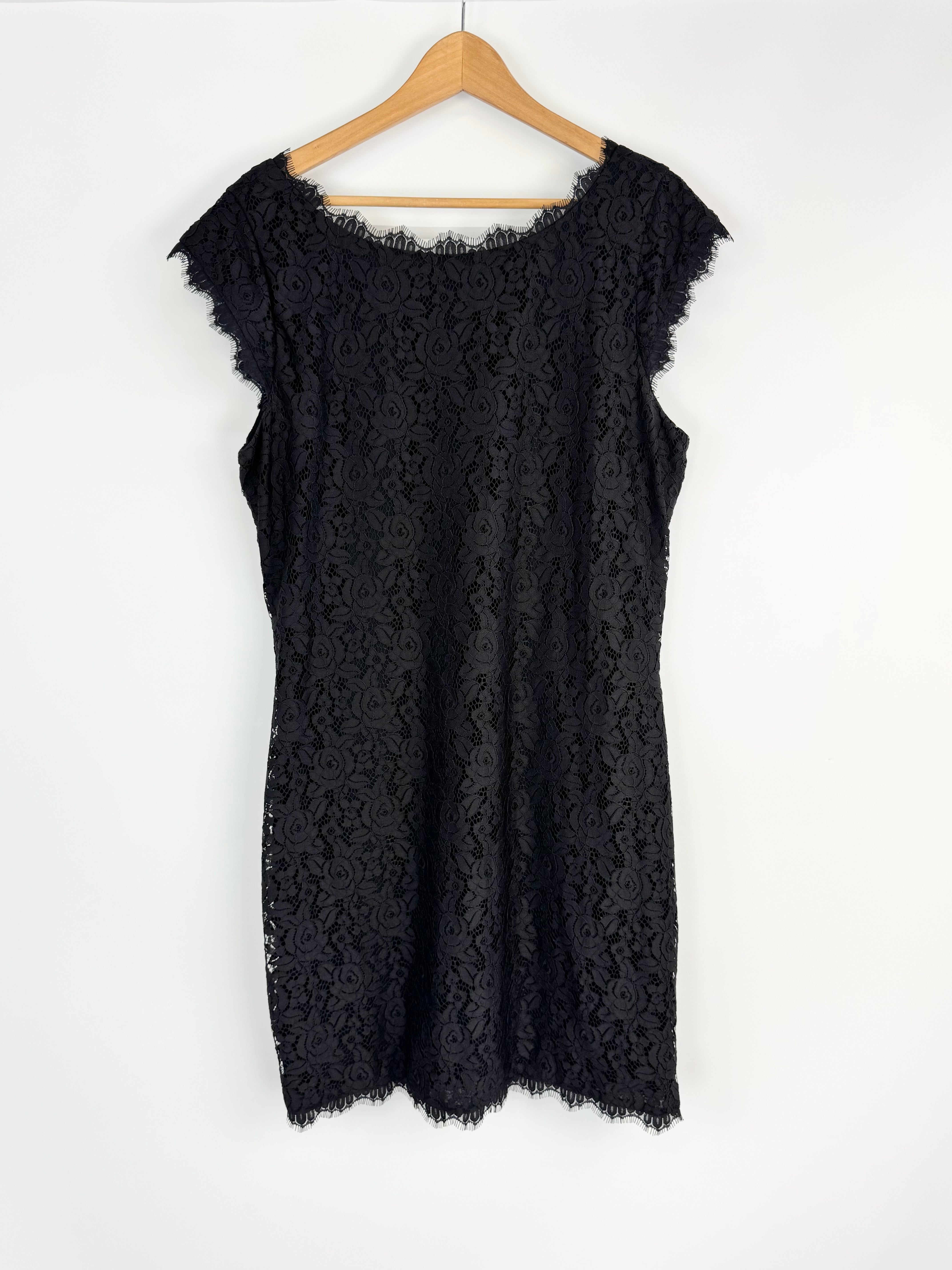 Black lace dress on a wooden hanger against a white background