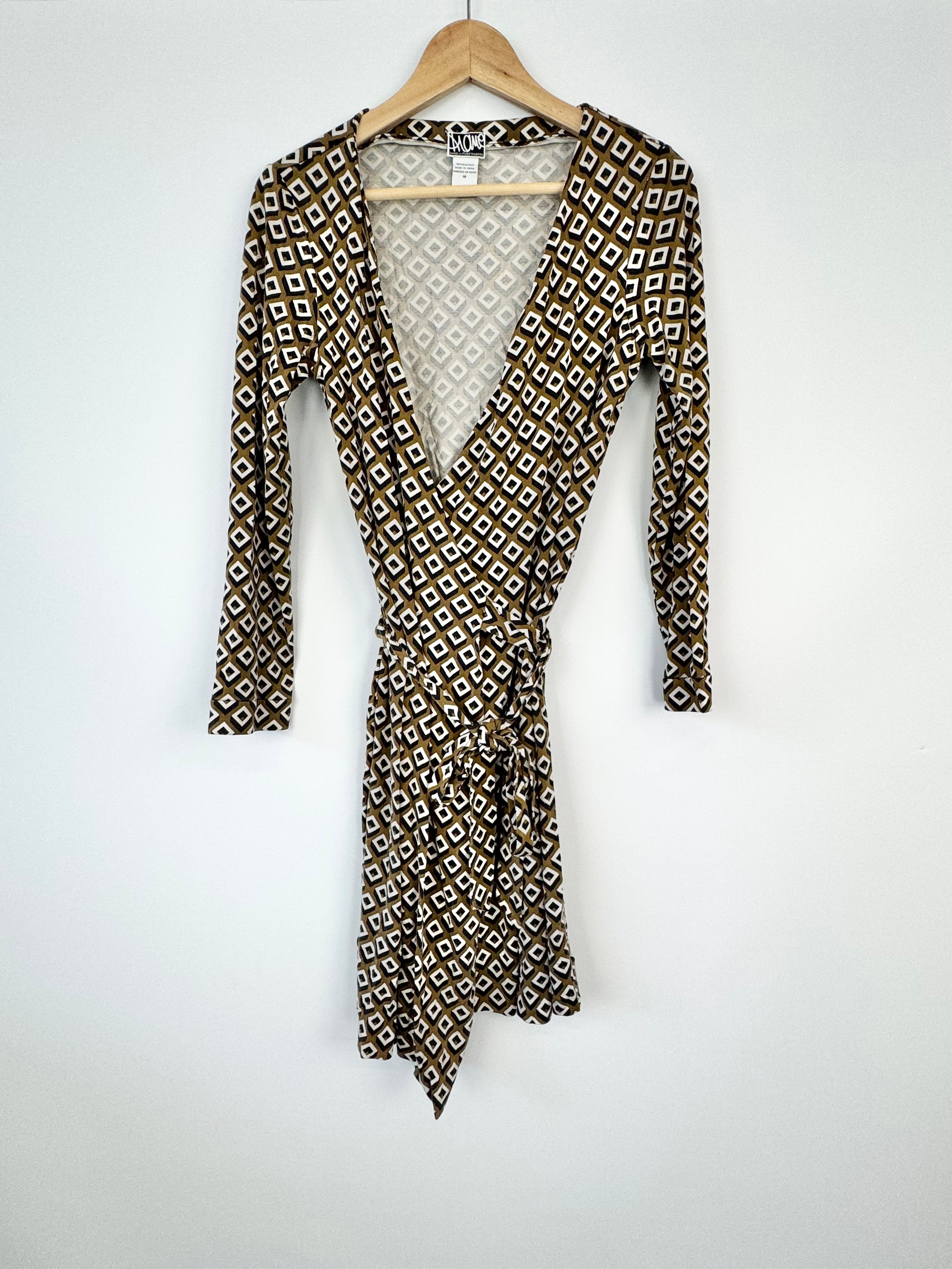 Patterned dress on a hanger against a white background