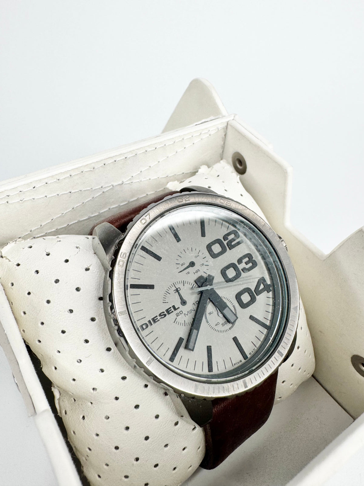Diesel watch with a brown leather strap in a box on a white background
