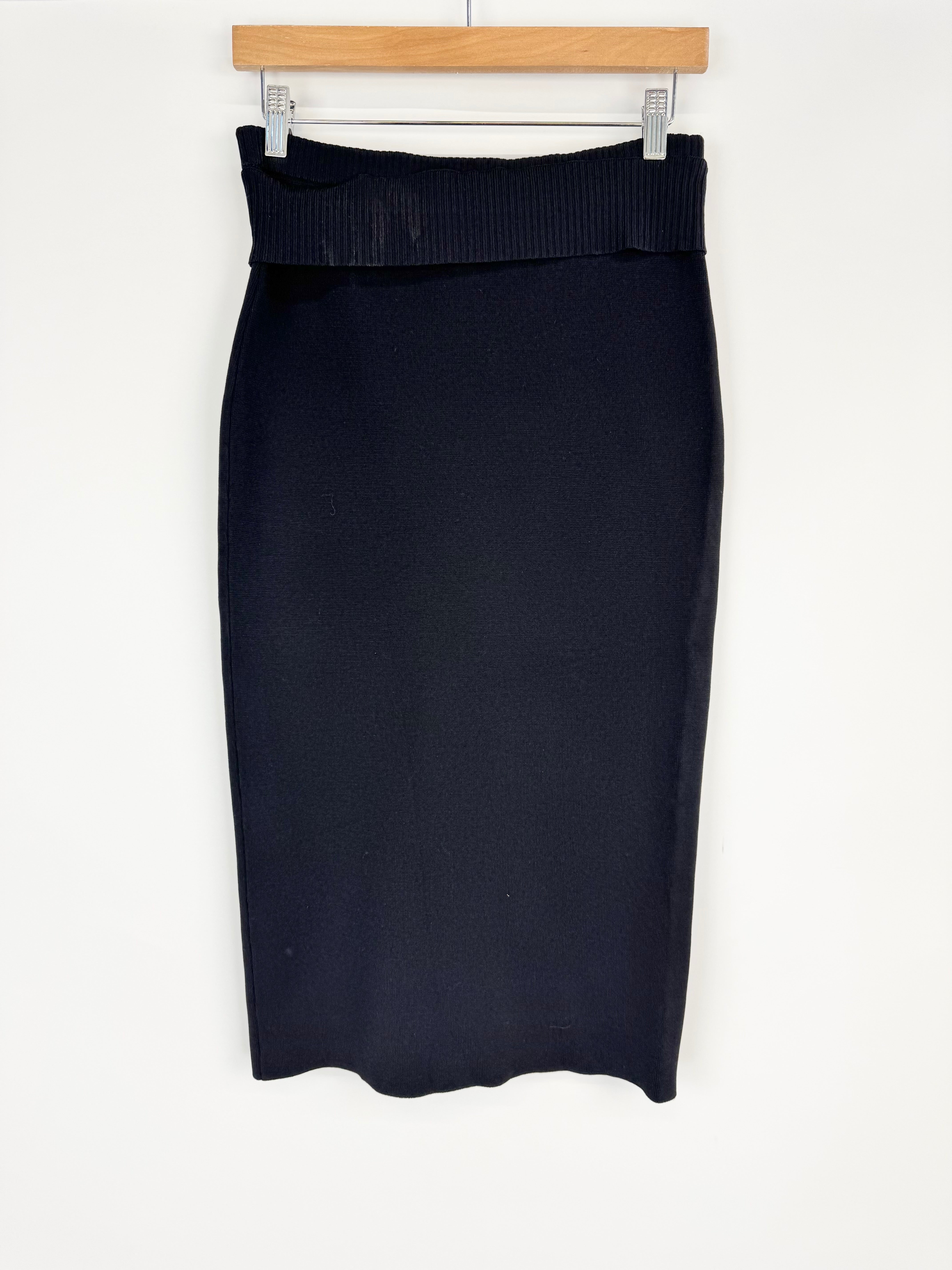 Black pencil skirt on a hanger against a white background