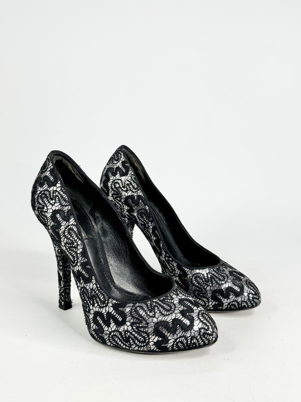 Black high-heeled shoes with white lace pattern on a white background