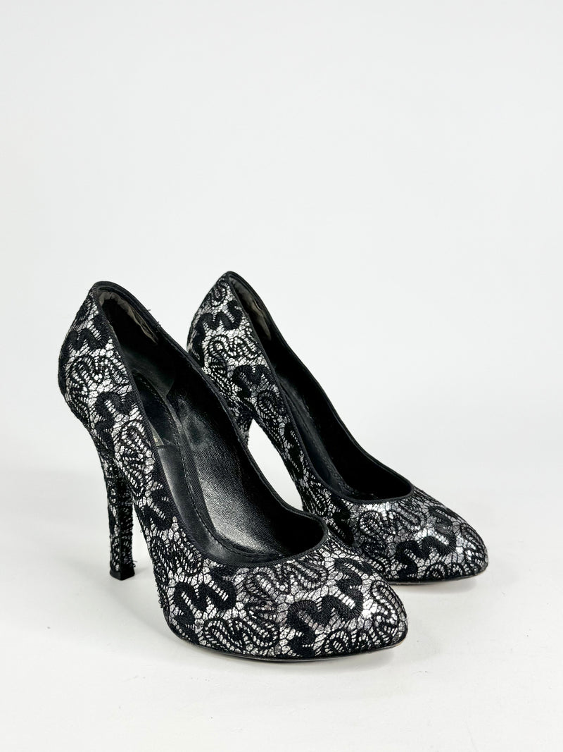Black high-heeled shoes with white lace pattern on a white background