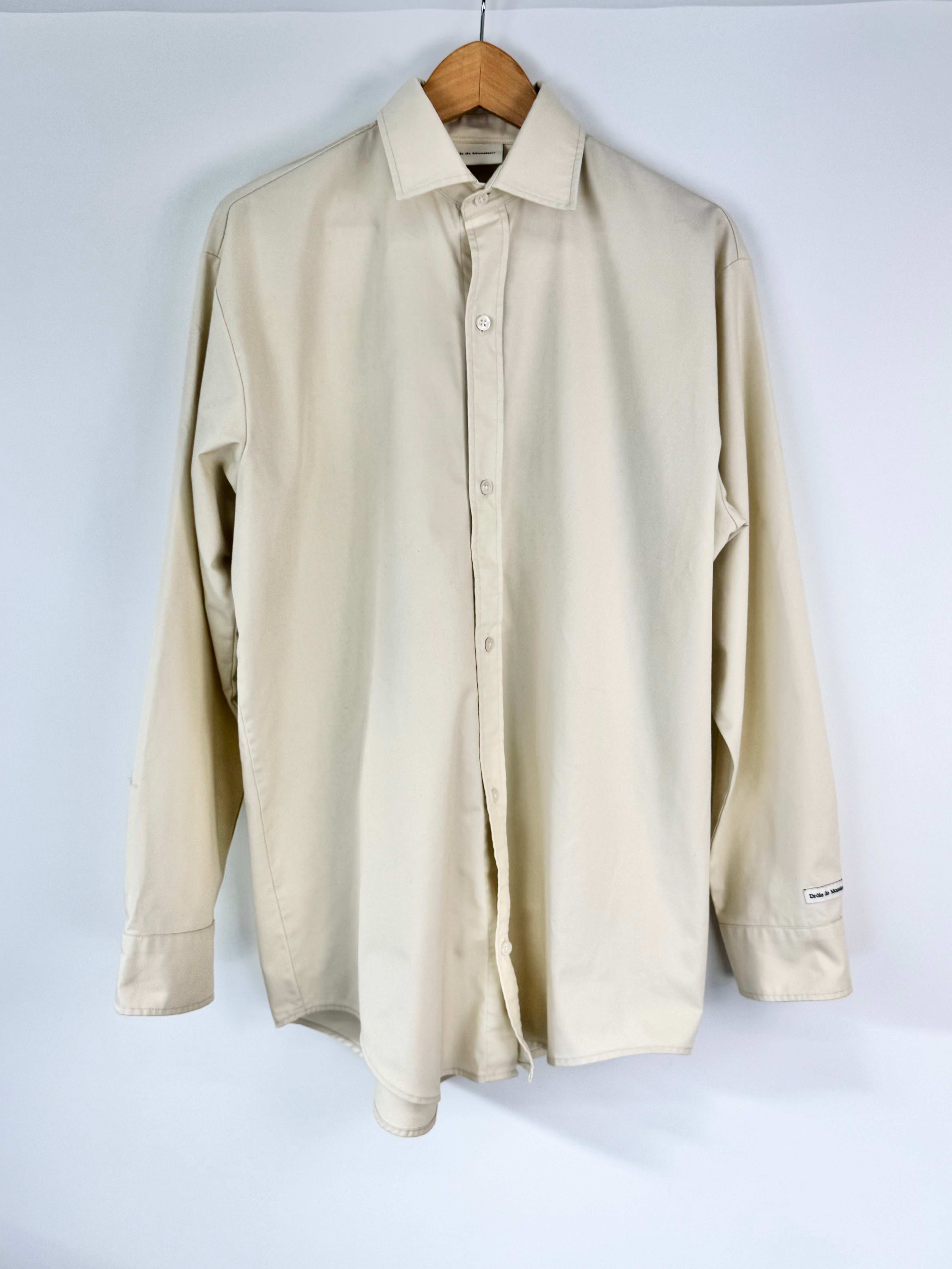 Beige shirt on a hanger against a white background