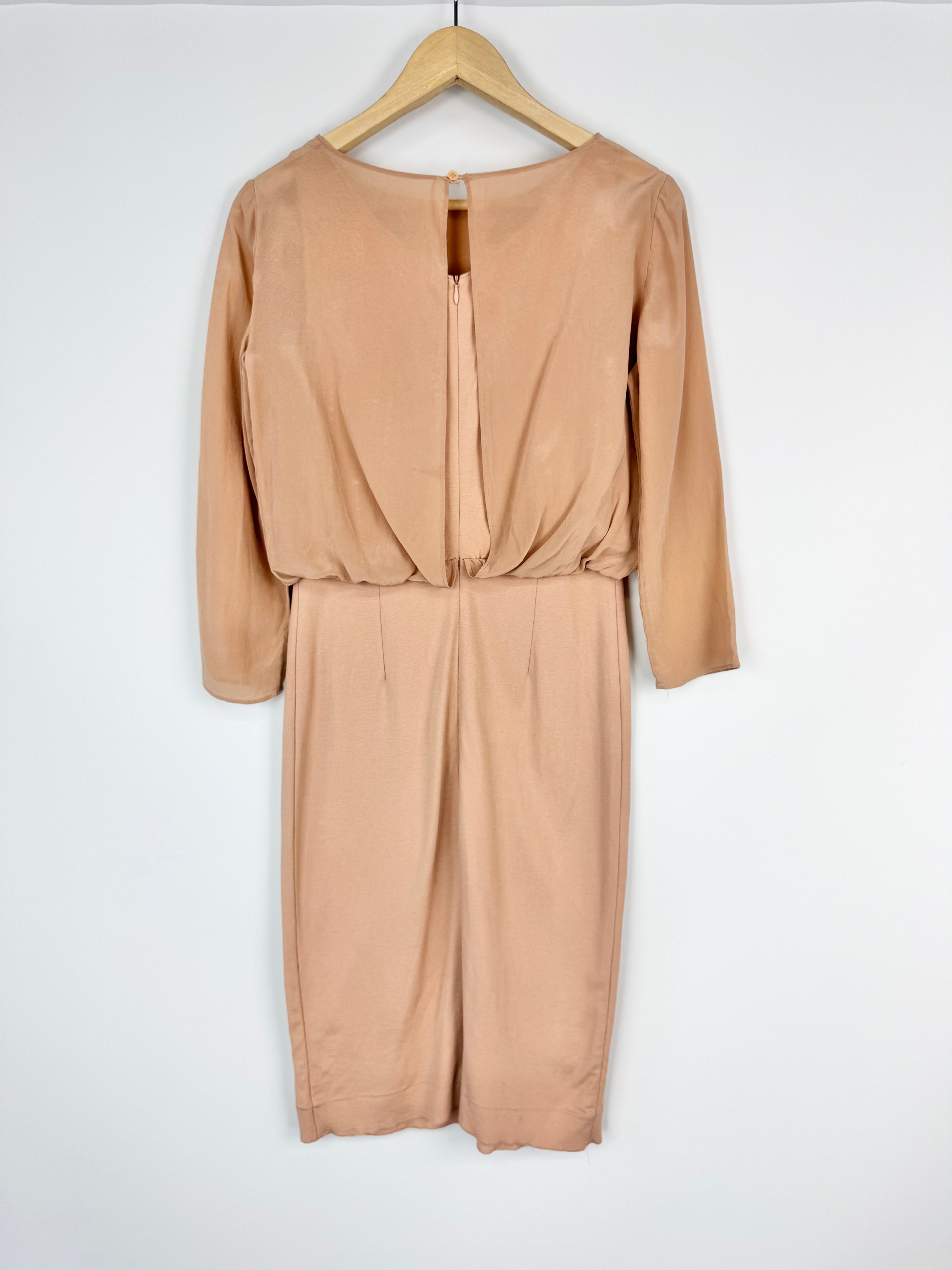 Beige jumpsuit on a hanger against a white background