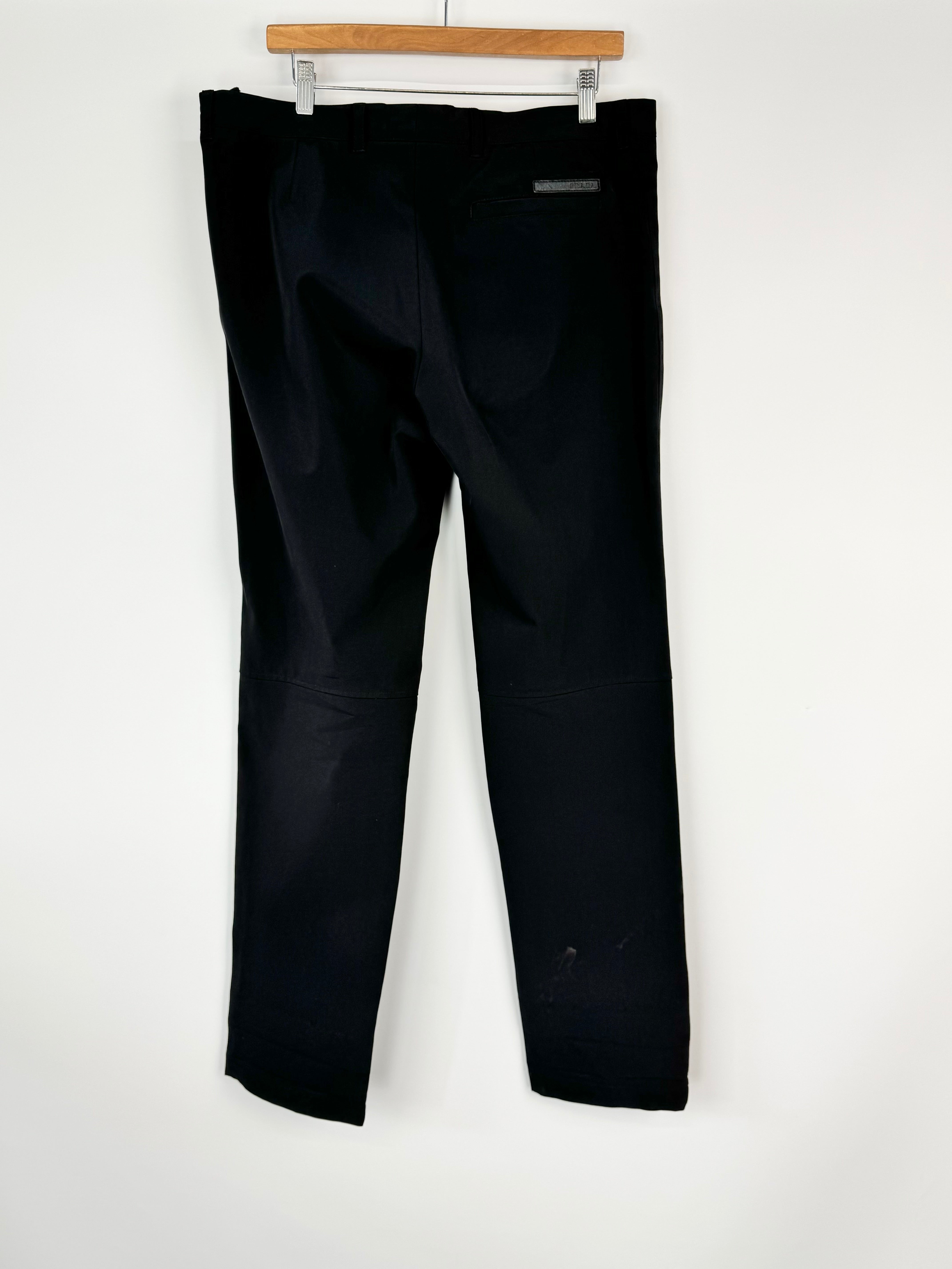 Black pants on a hanger against a white background