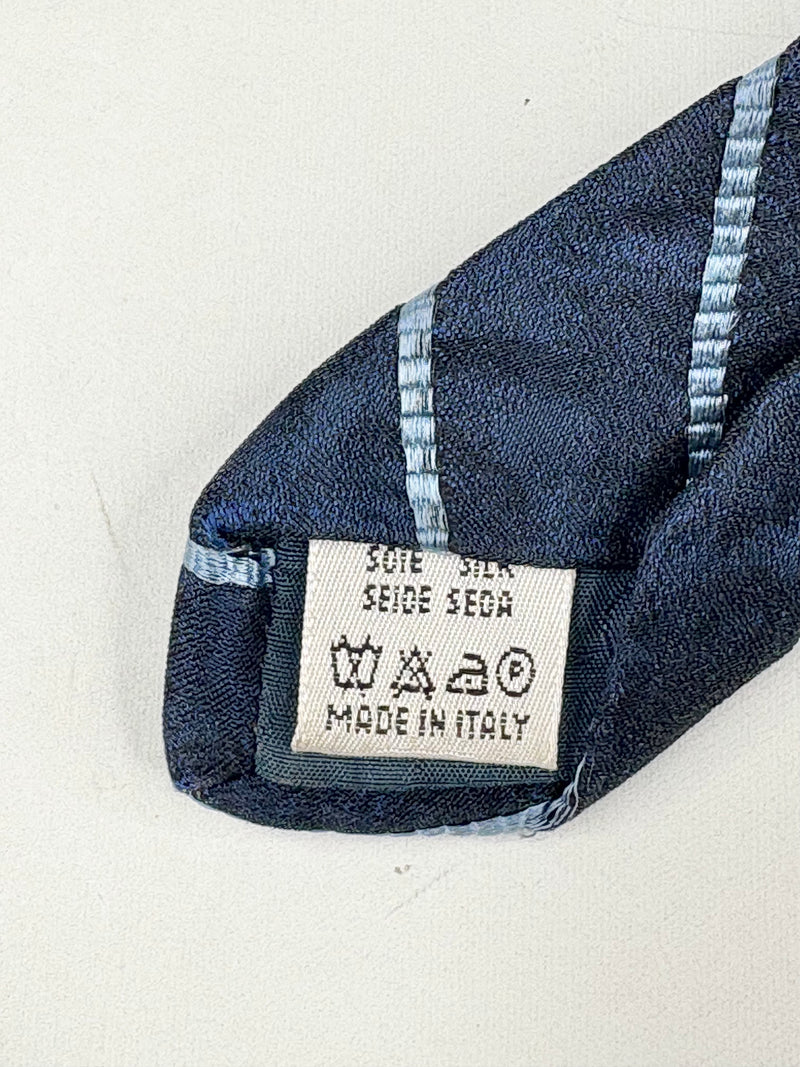 Close-up of a blue silk tie with a label on a white background