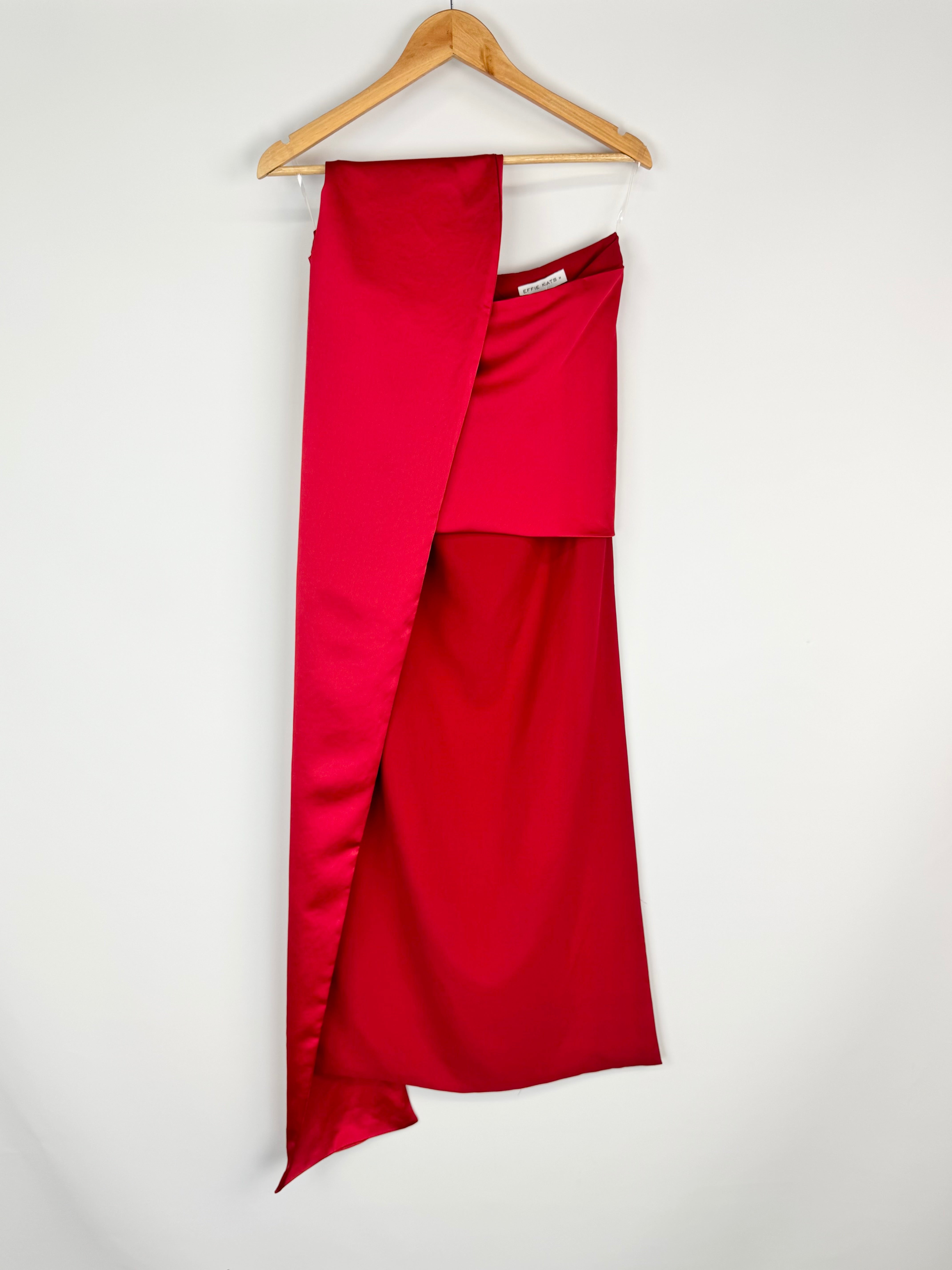Red skirt on a wooden hanger against a white background