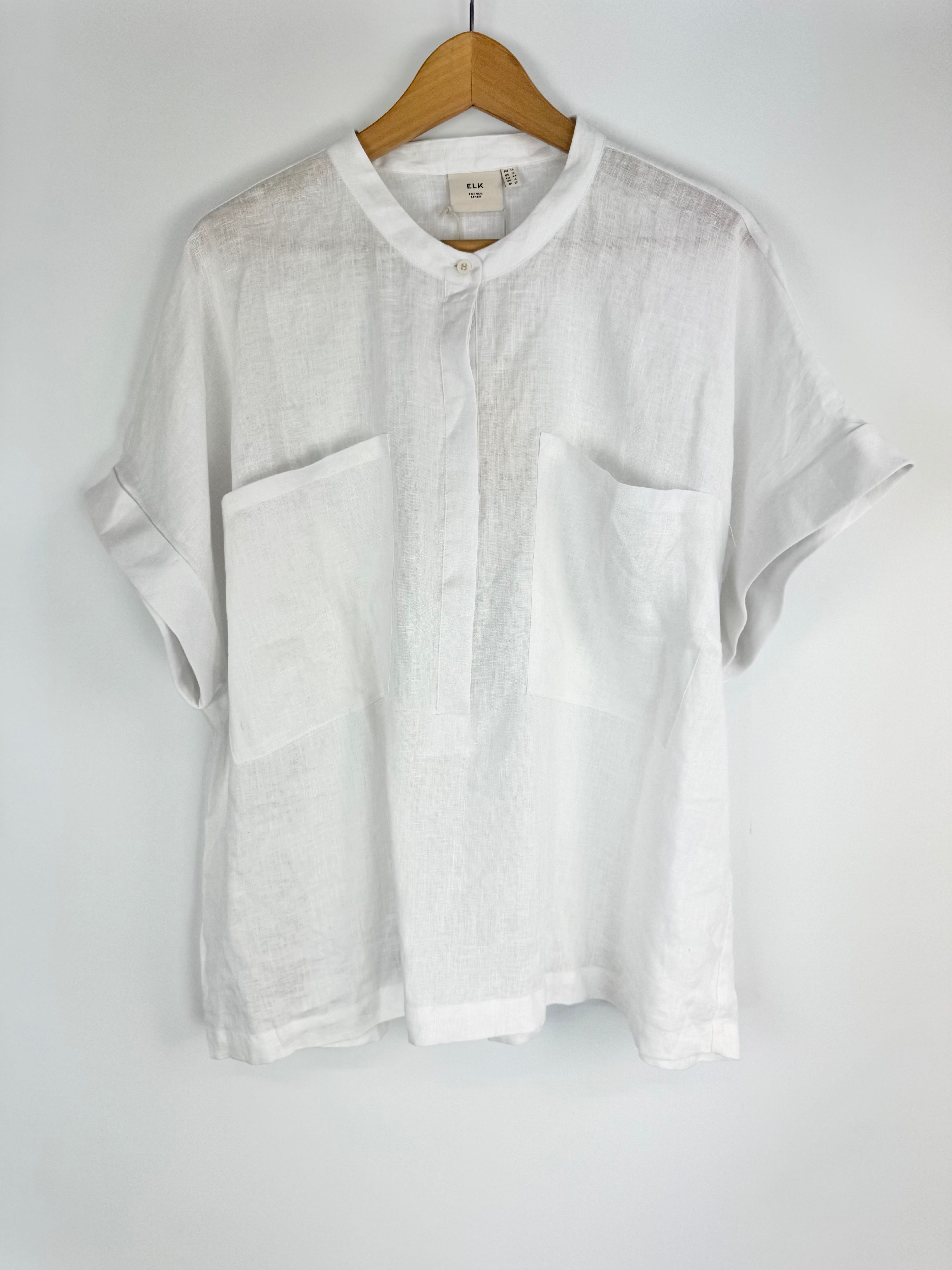 White shirt on a hanger against a white background