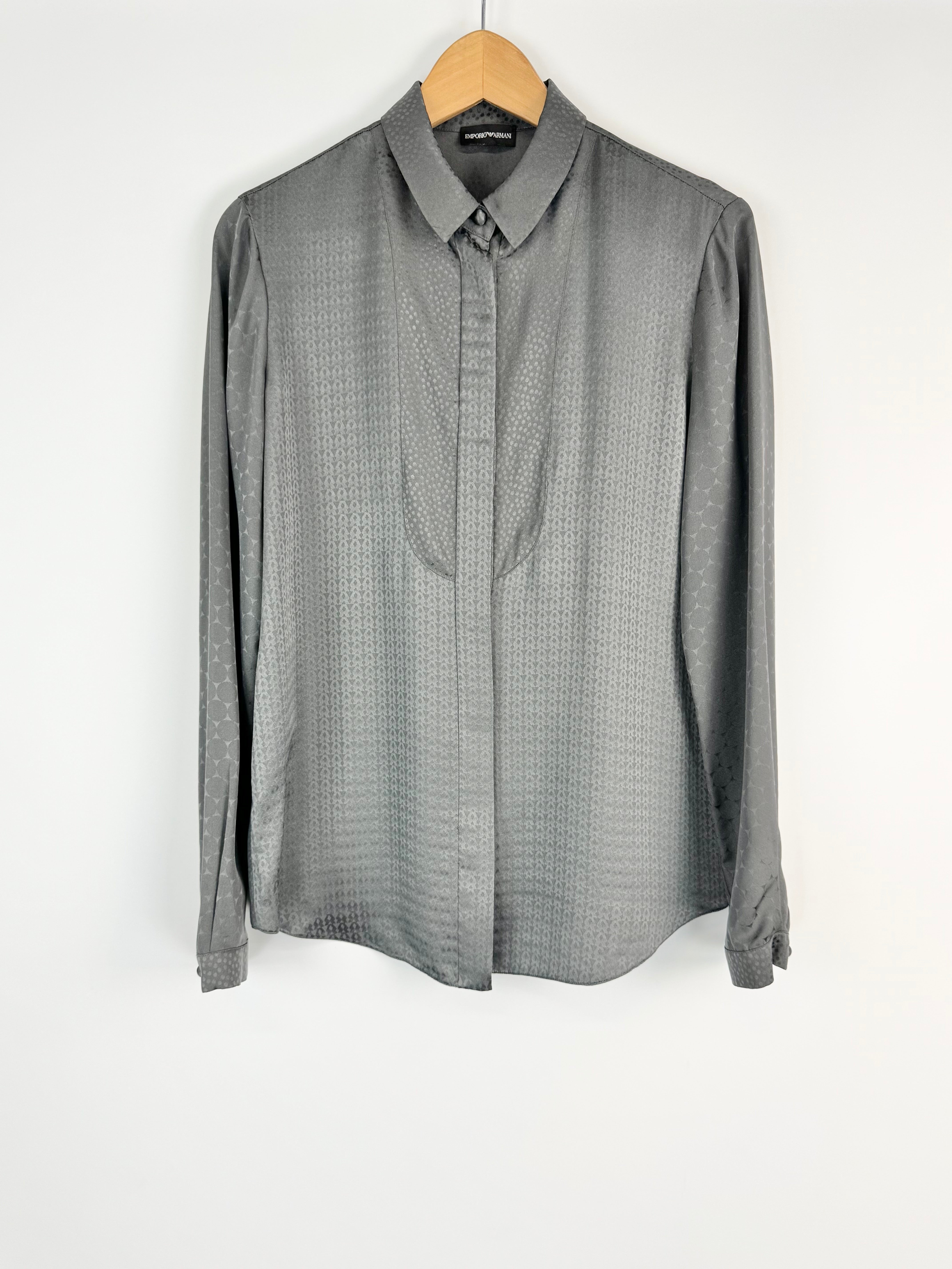 Gray dotted shirt on a hanger against a white background