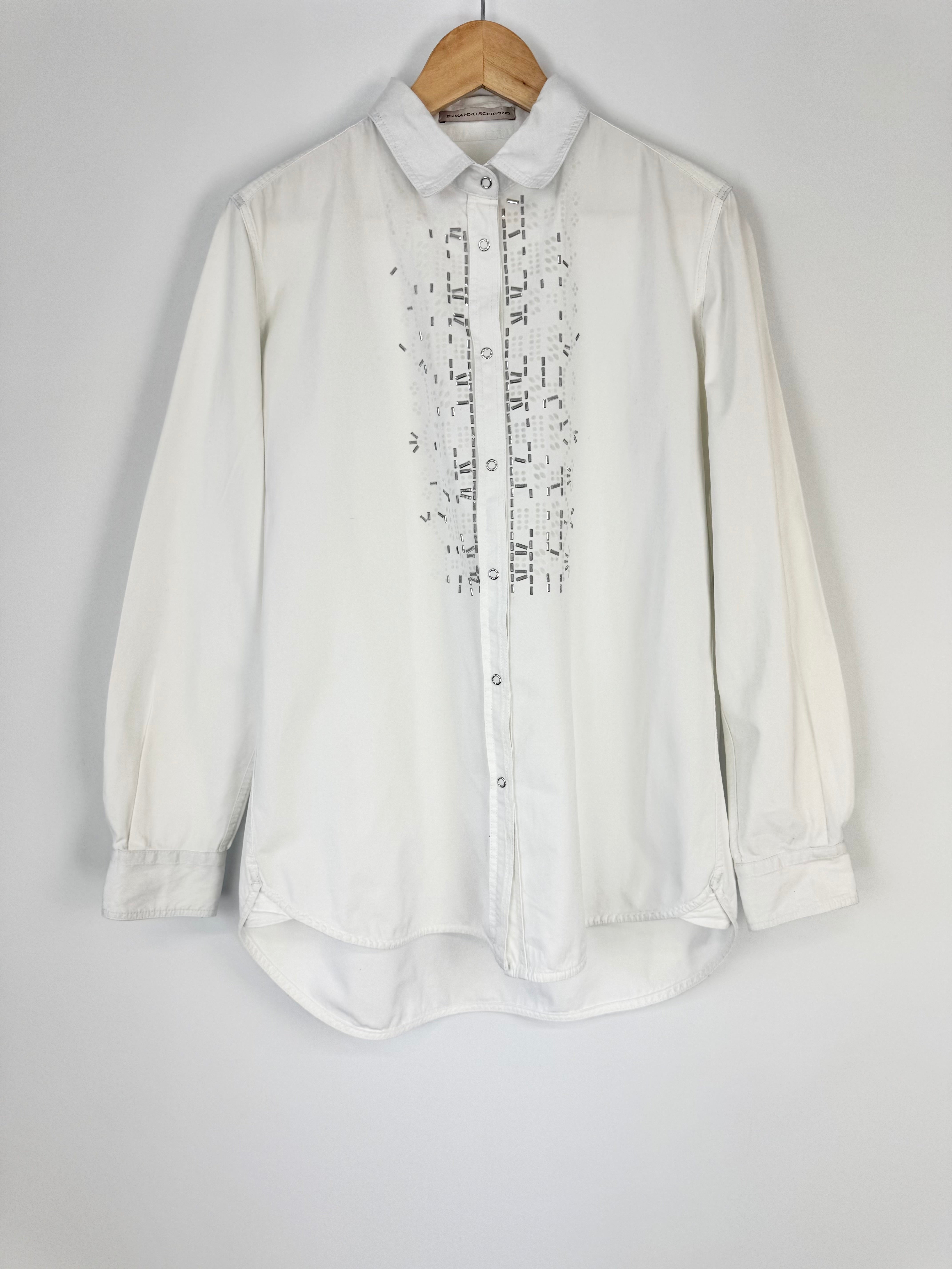White shirt with black pattern on a hanger against a gray background