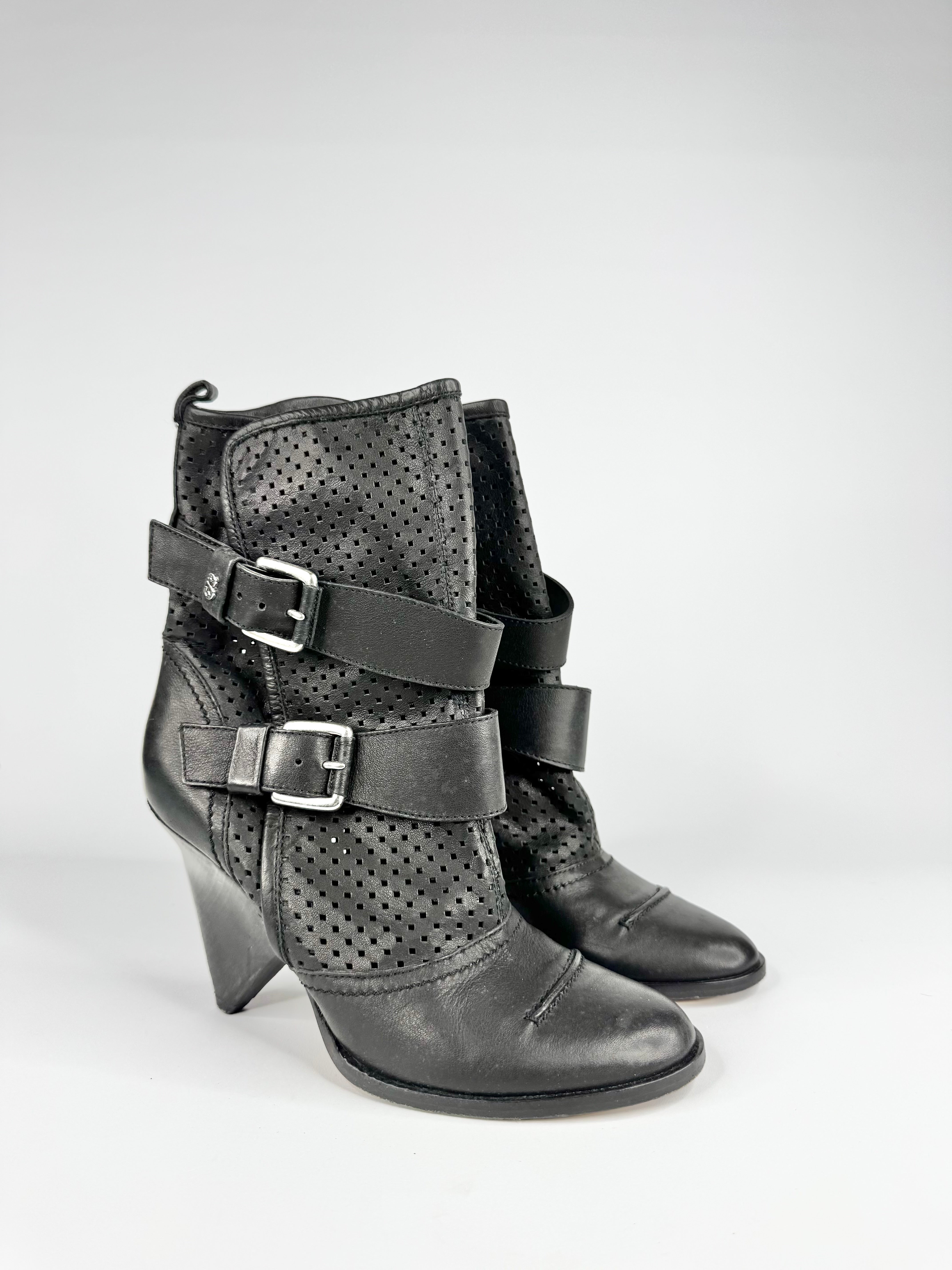 Pair of black leather ankle boots with buckles on a white background