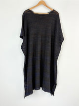 Black tunic on a hanger against a white background