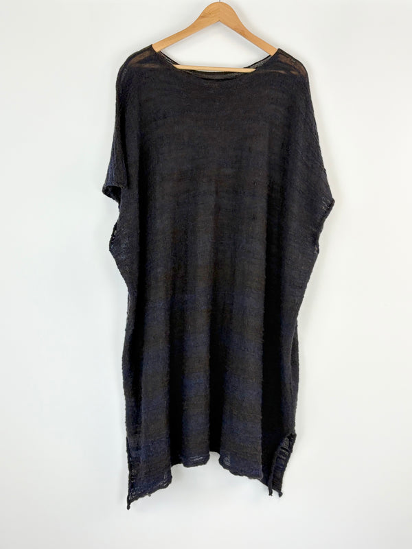 Black tunic on a hanger against a white background