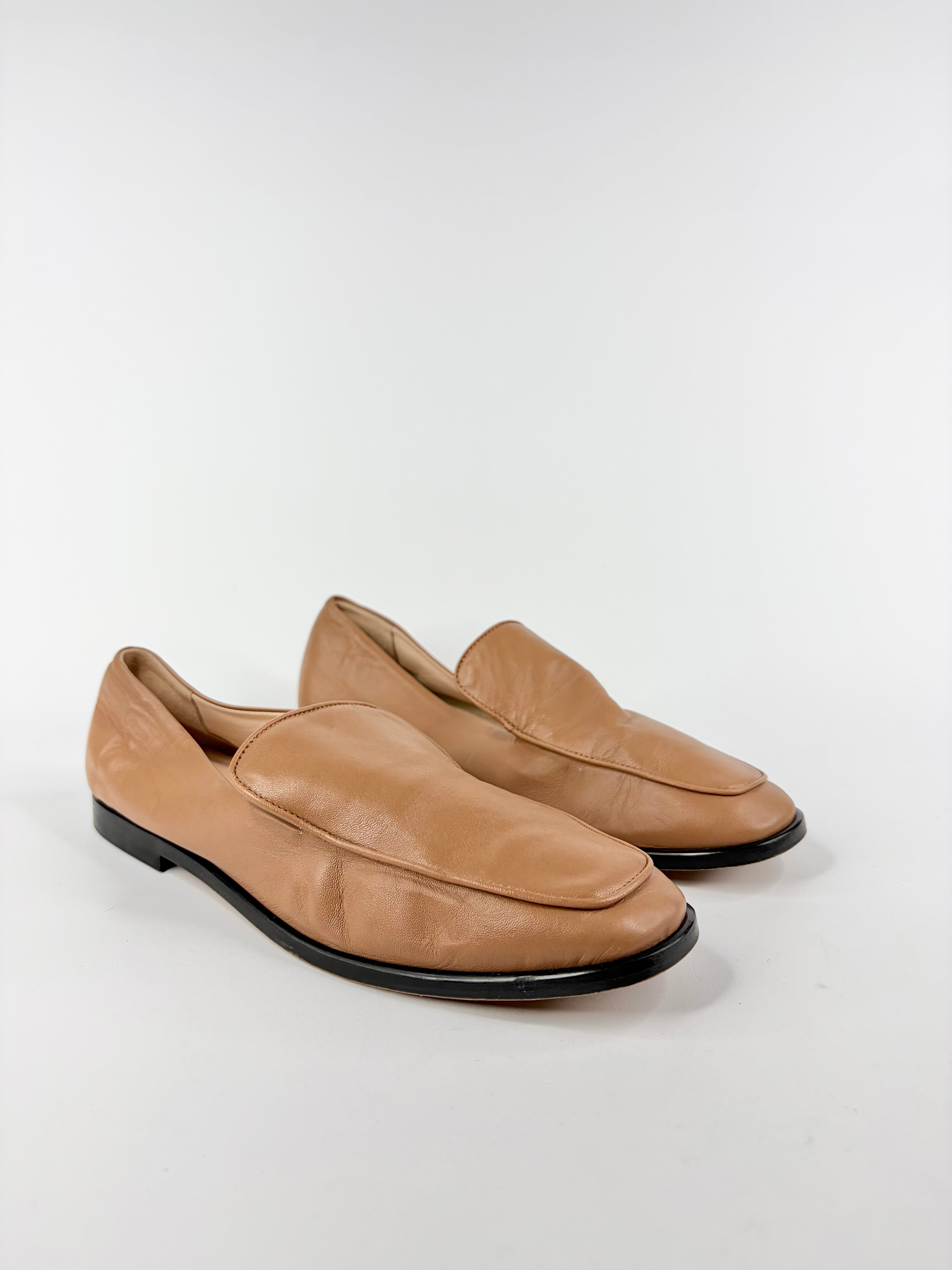 Pair of tan loafers on a white background