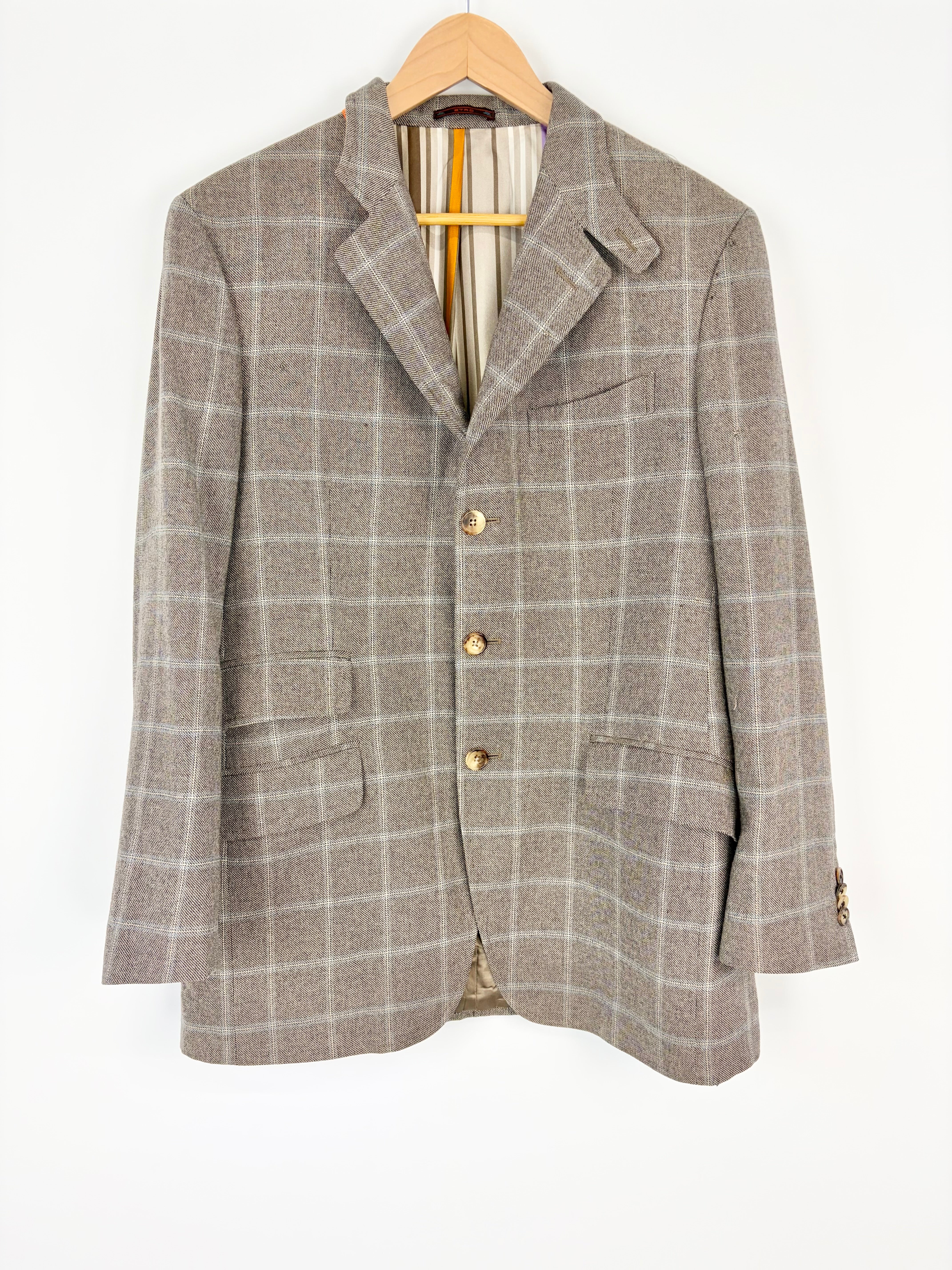 Plaid blazer on a hanger against a white background
