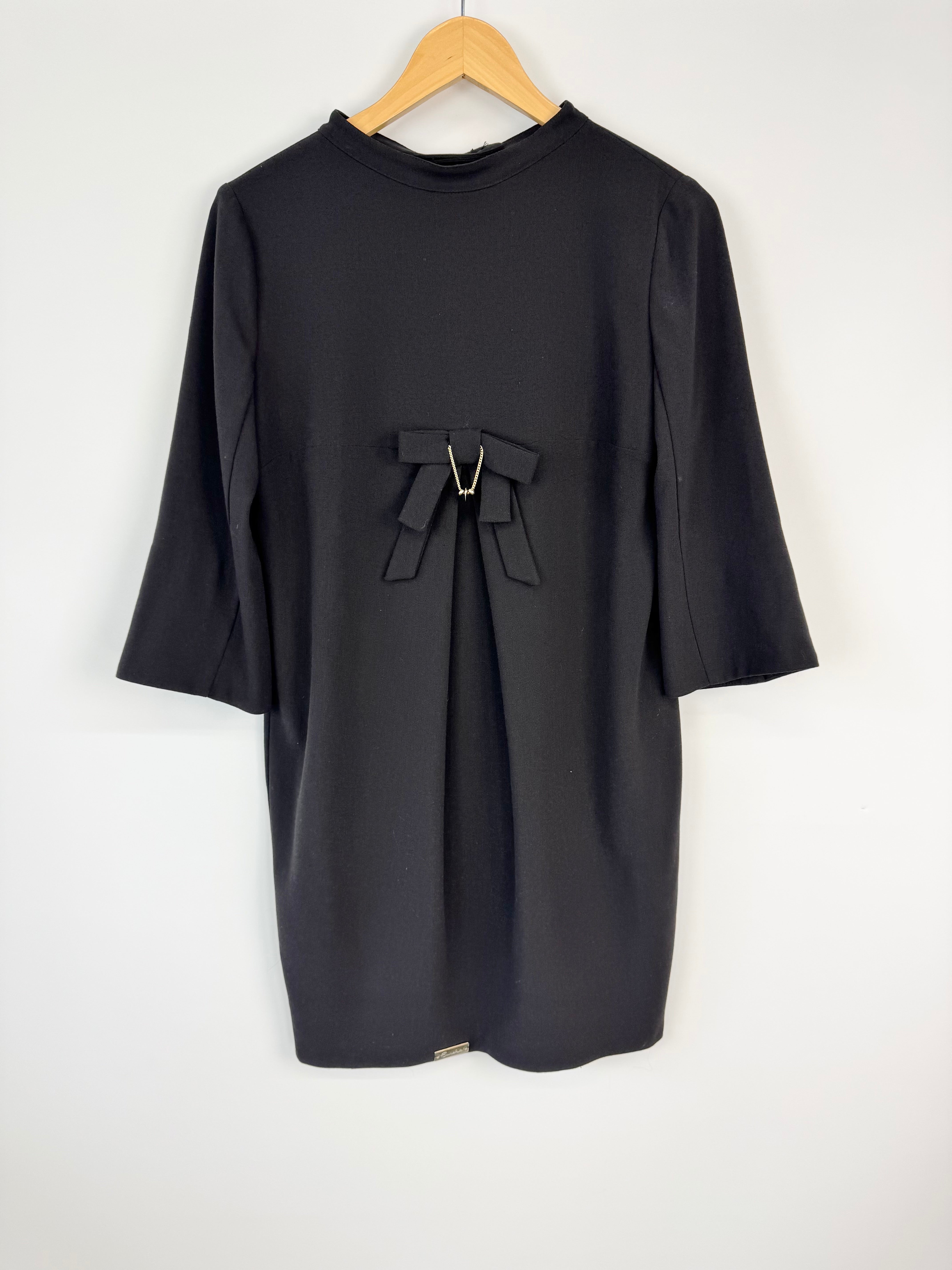 Black dress with a bow detail on a white background