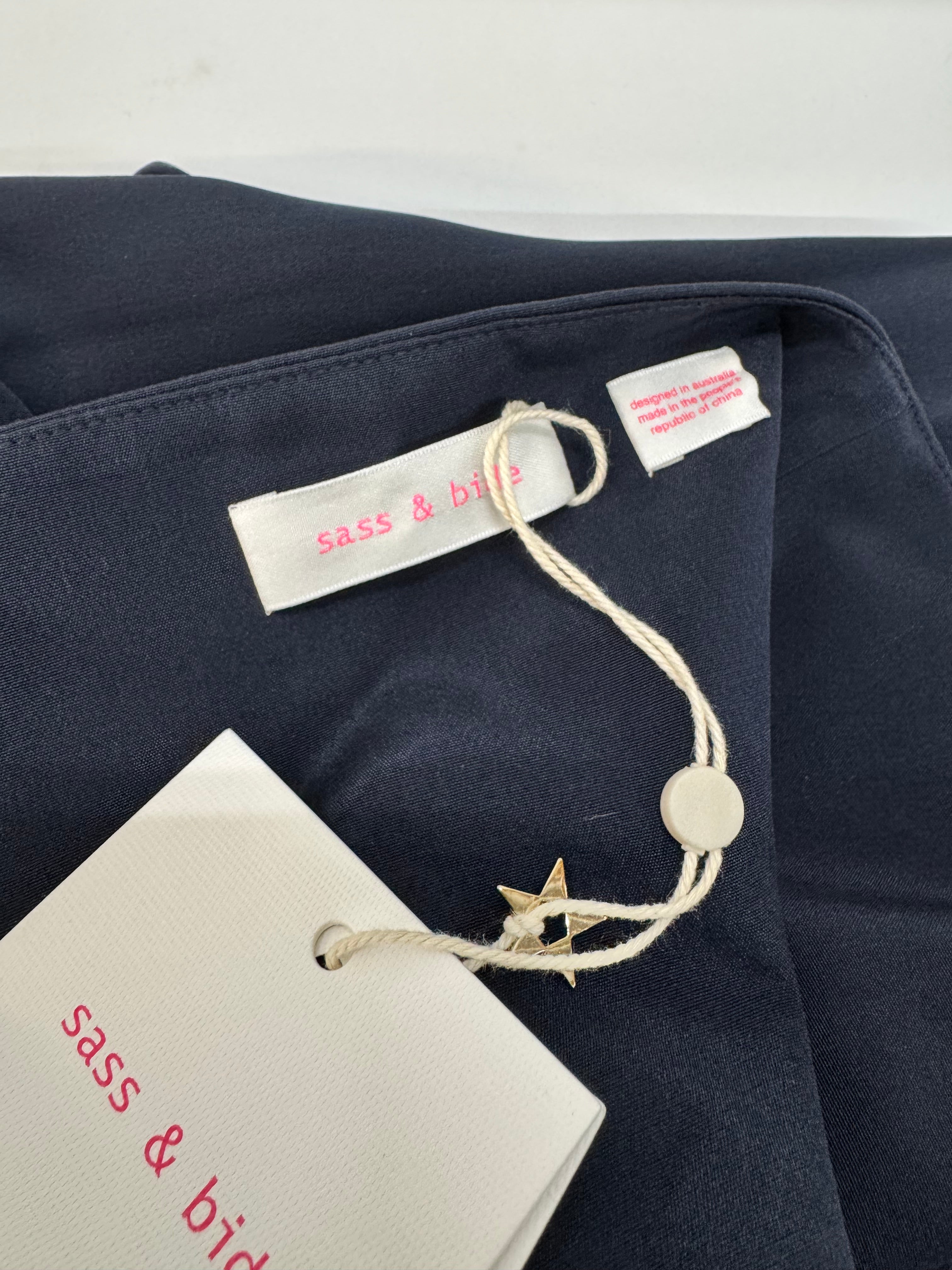 Navy blue fabric with 'sass & bide' tags and label on a white background
