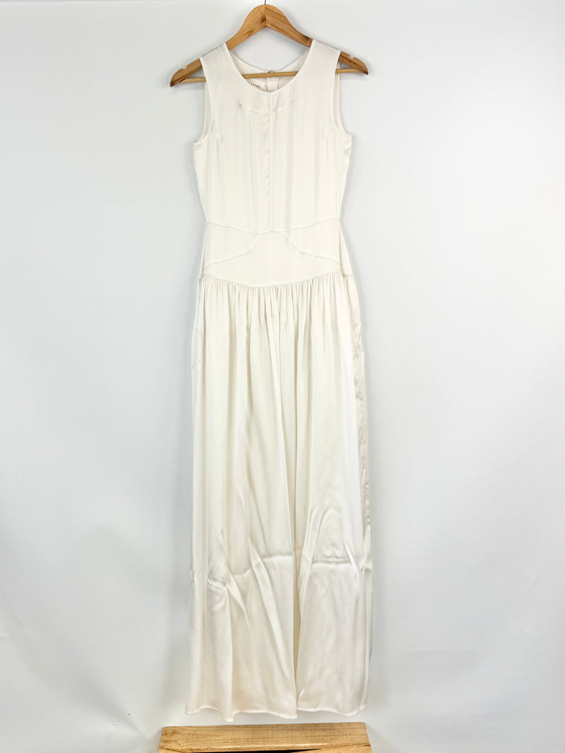 White sleeveless dress on a wooden hanger against a white background