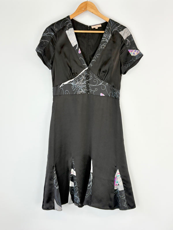Black Fleur Wood dress with floral patterns on a hanger against a white background