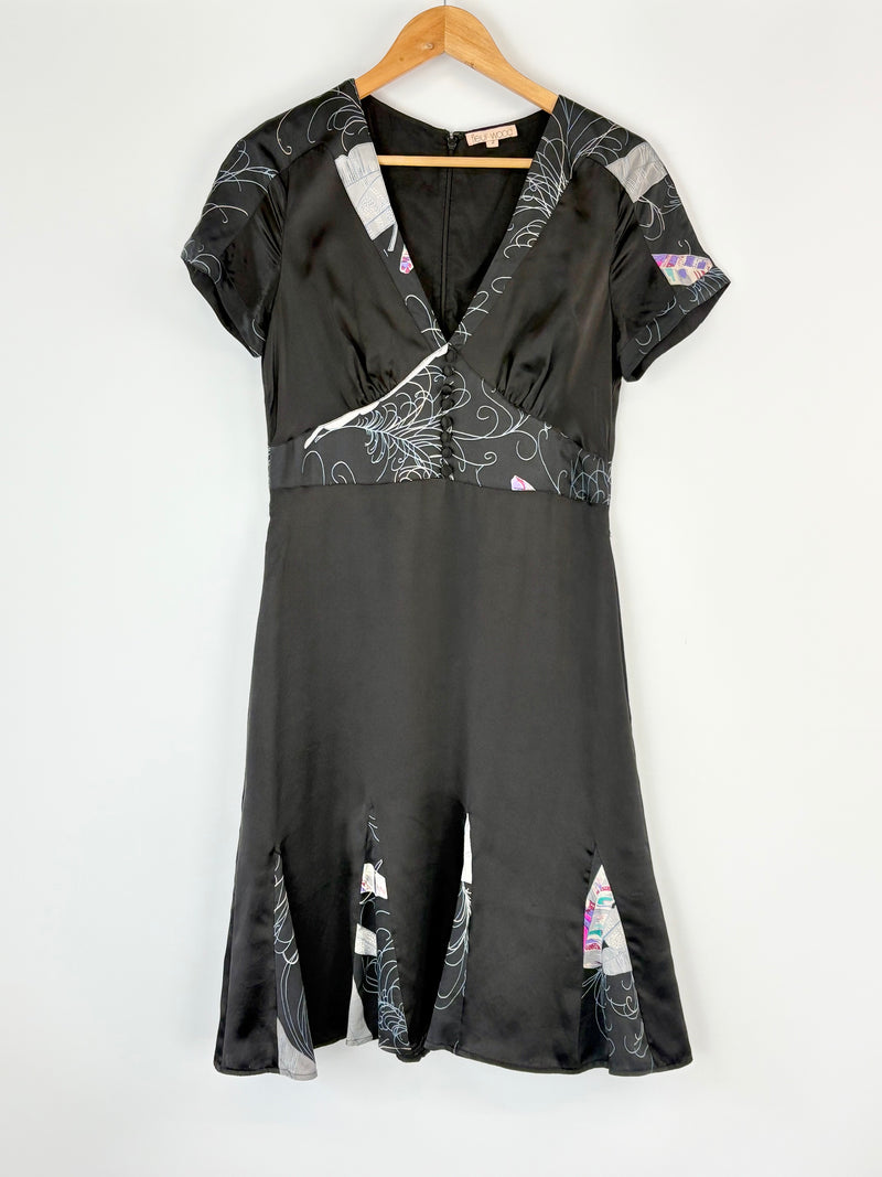 Black Fleur Wood dress with floral patterns on a hanger against a white background