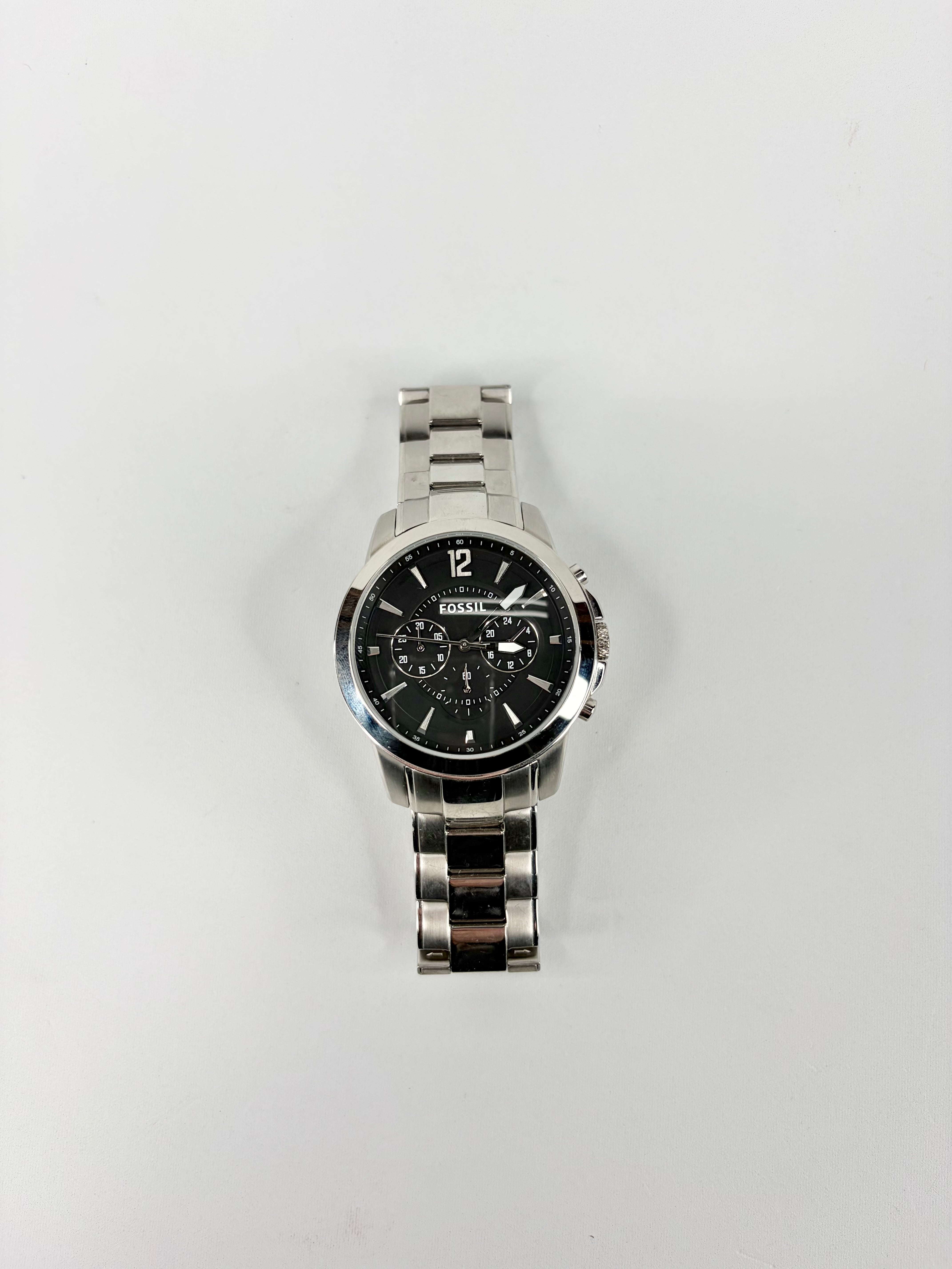 Silver watch with a black face on a white background
