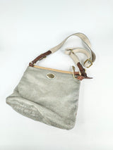 Textured handbag with brown handle and strap on a white background