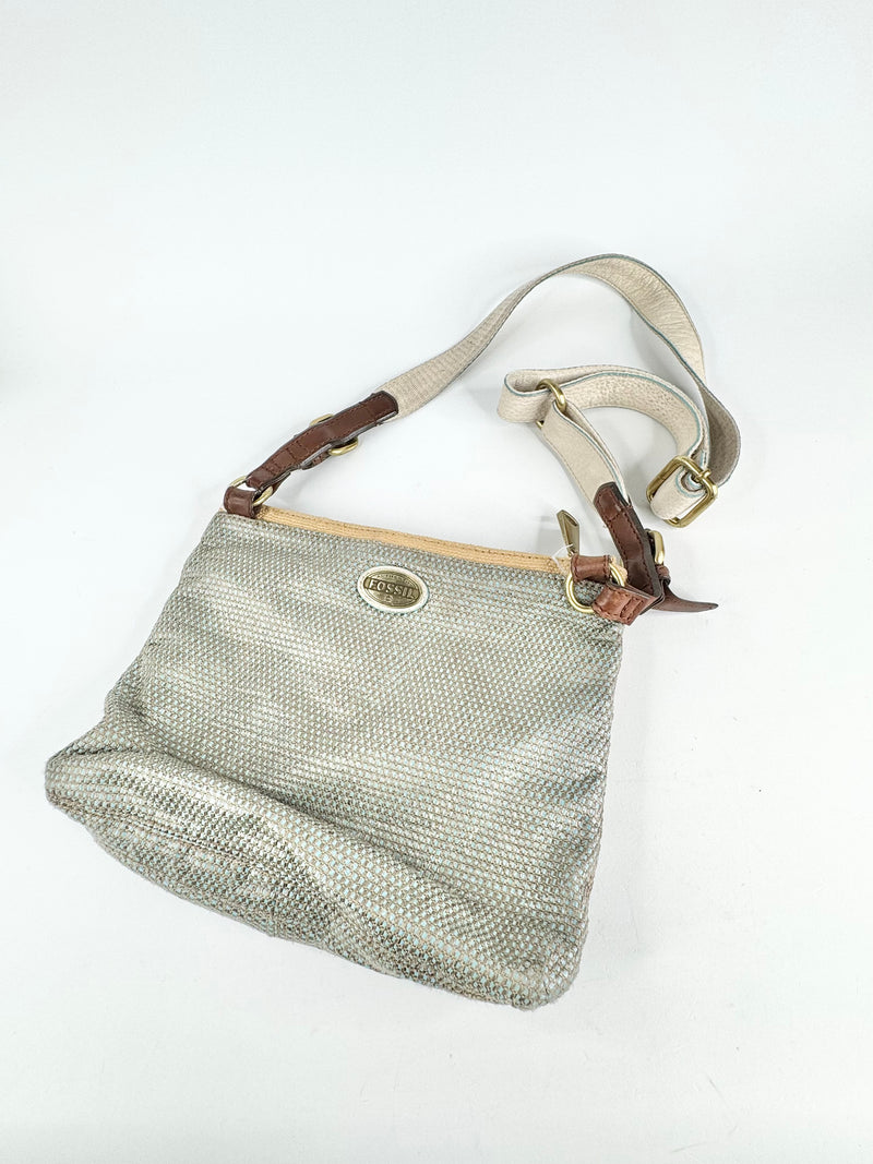 Textured handbag with brown handle and strap on a white background