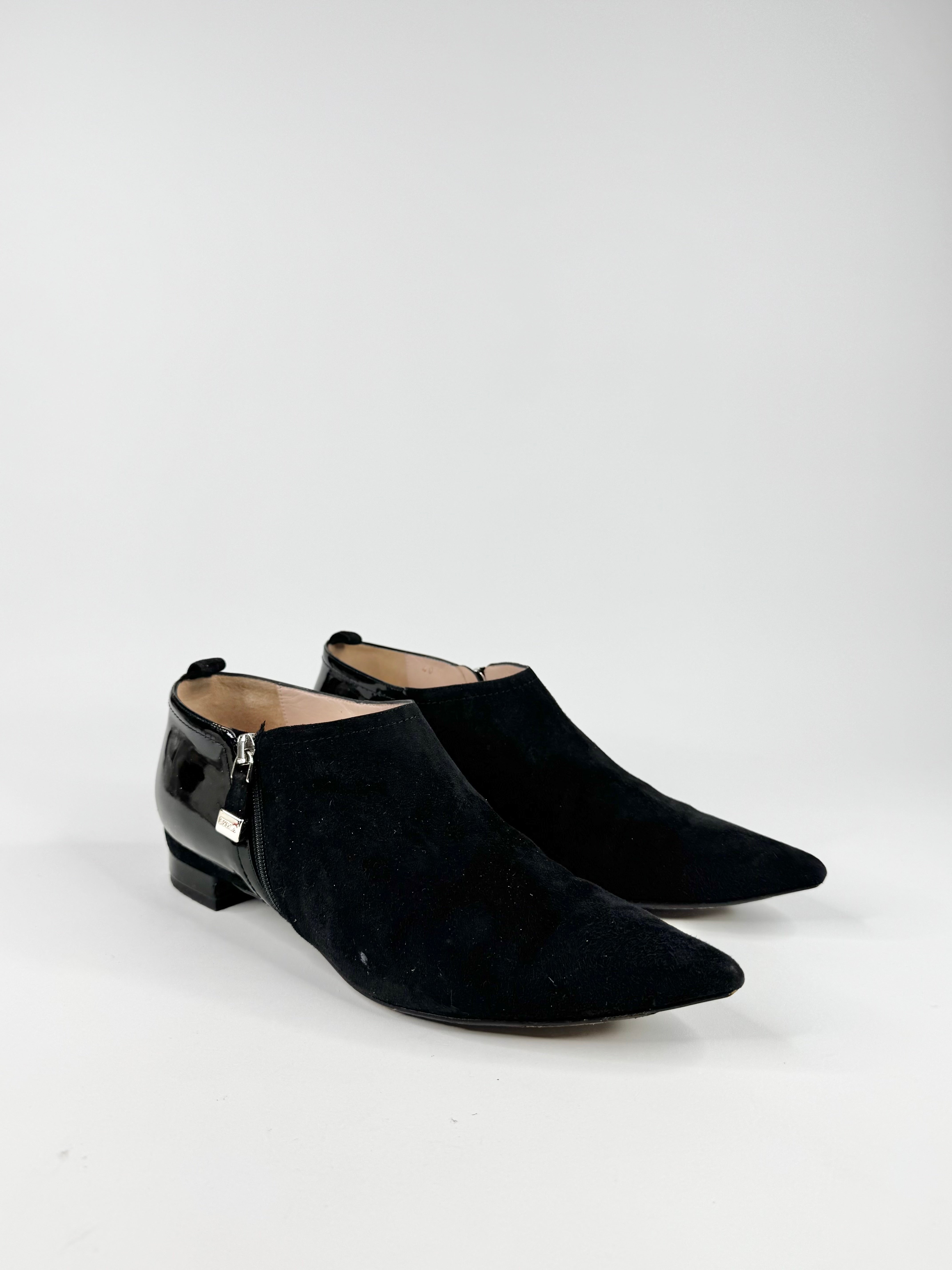 Pair of black suede shoes on a white background