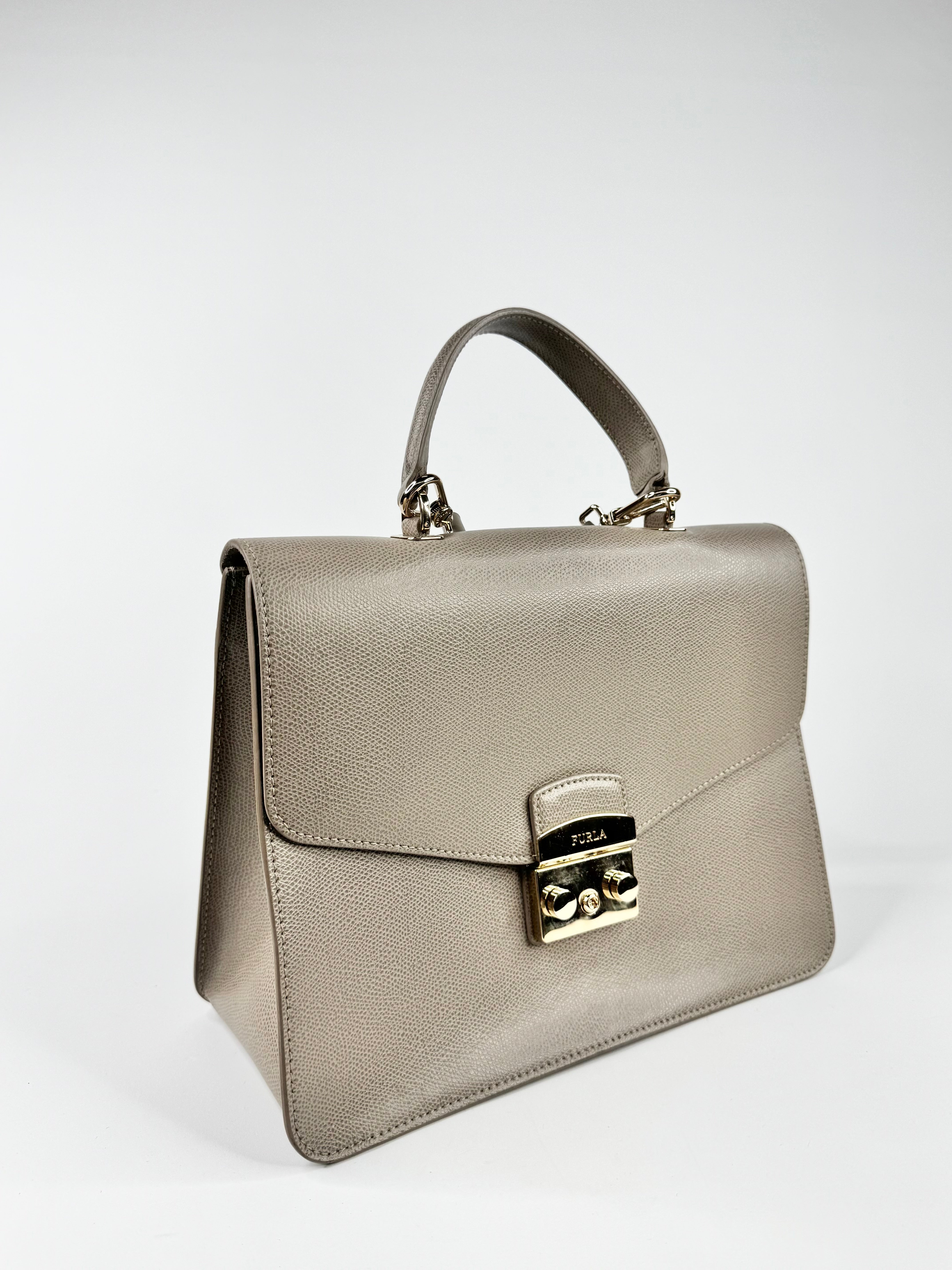 Beige handbag with gold accents on a white background