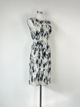Sleeveless midi dress with abstract black and white print and triangle cut-out panels on the waist, displayed on a mannequin.