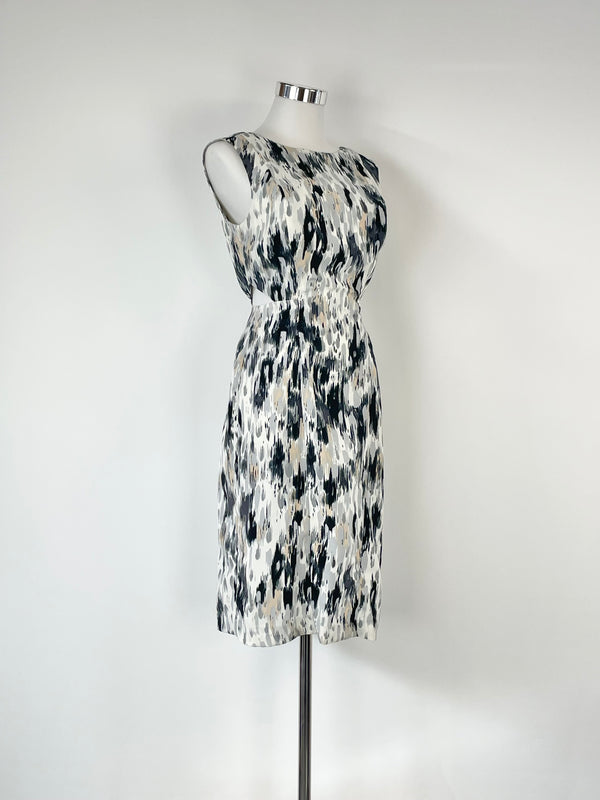 Sleeveless midi dress with abstract black and white print and triangle cut-out panels on the waist, displayed on a mannequin.