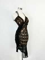 A black lace mini dress with a halter neck tie and a tiered skirt, displayed on a mannequin.