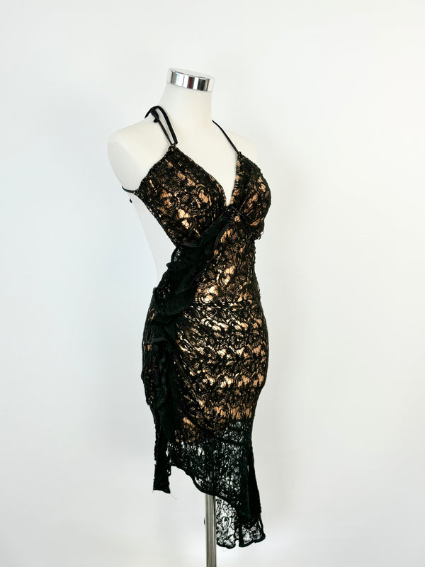 A black lace mini dress with a halter neck tie and a tiered skirt, displayed on a mannequin.