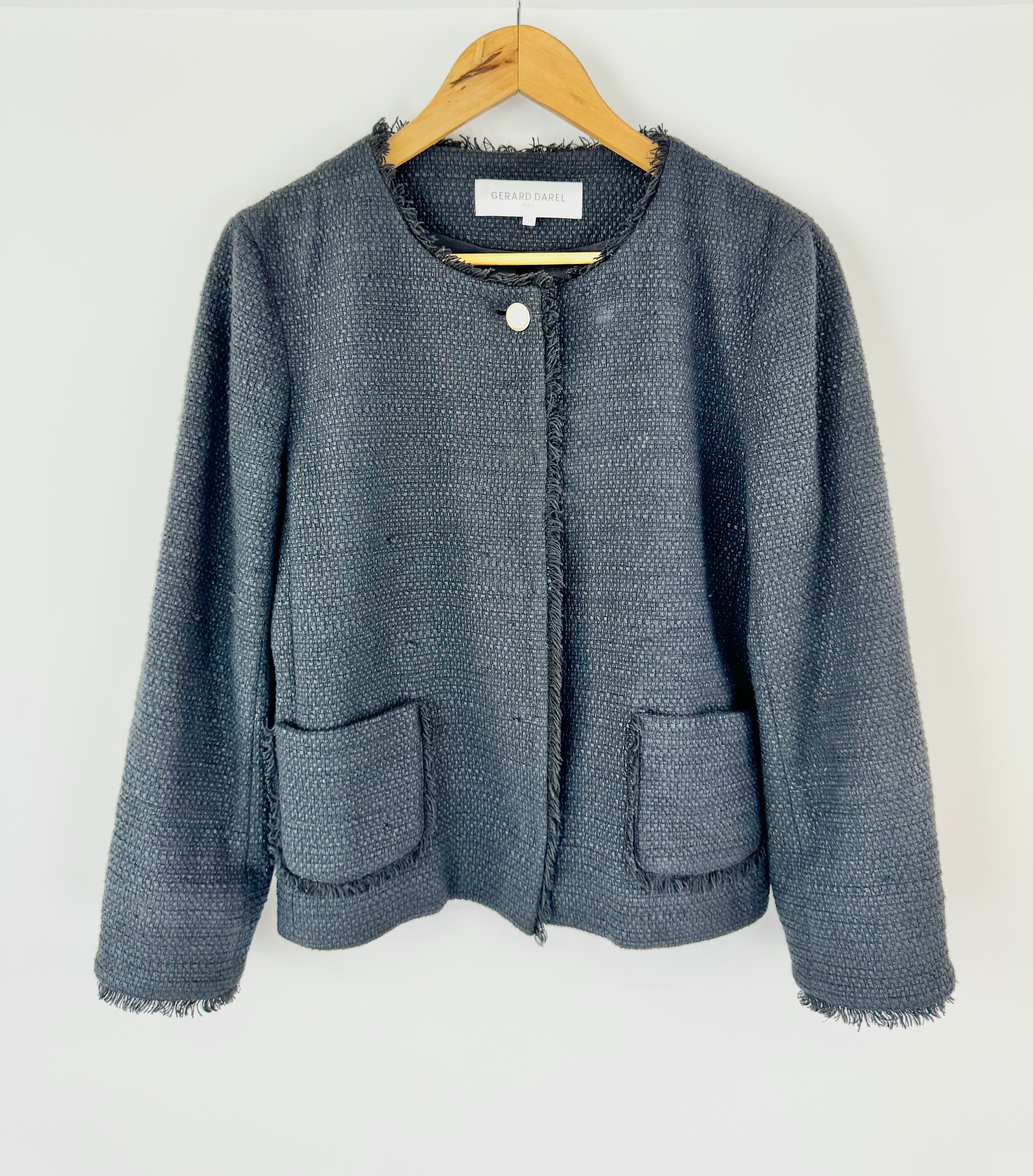 Black textured jacket on a hanger against a white background