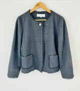 Black textured jacket on a hanger against a white background