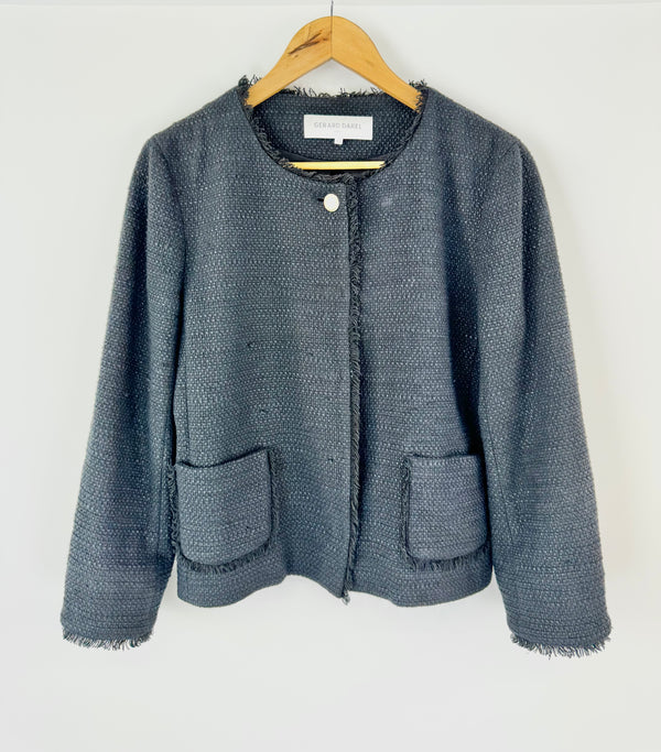 Black textured jacket on a hanger against a white background