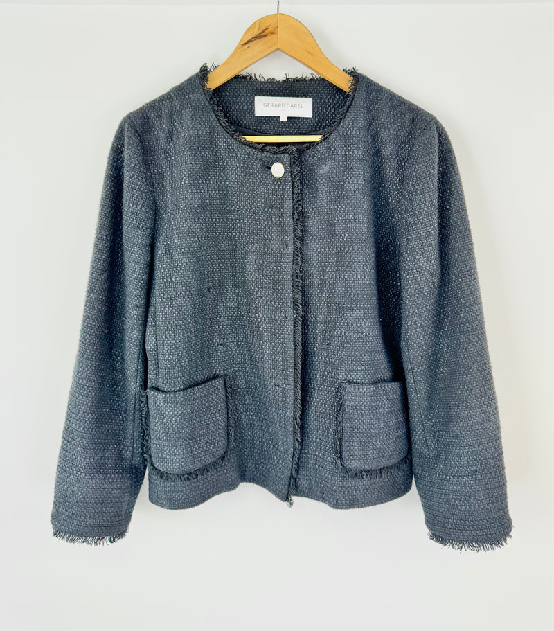 Black textured jacket on a hanger against a white background
