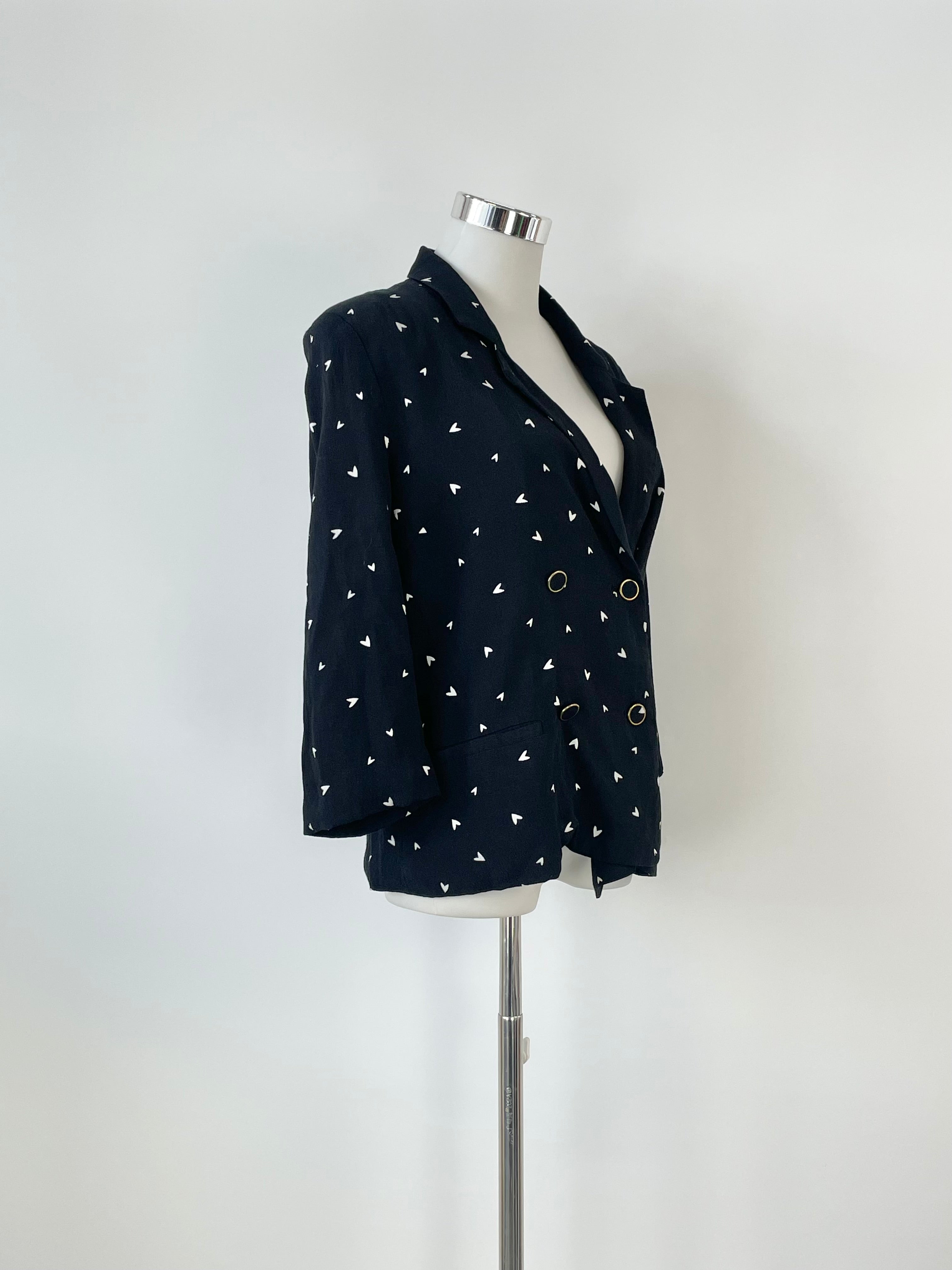 A black 'HoneyGZ' blazer with an abstract heart pattern displayed on a mannequin against a white background.