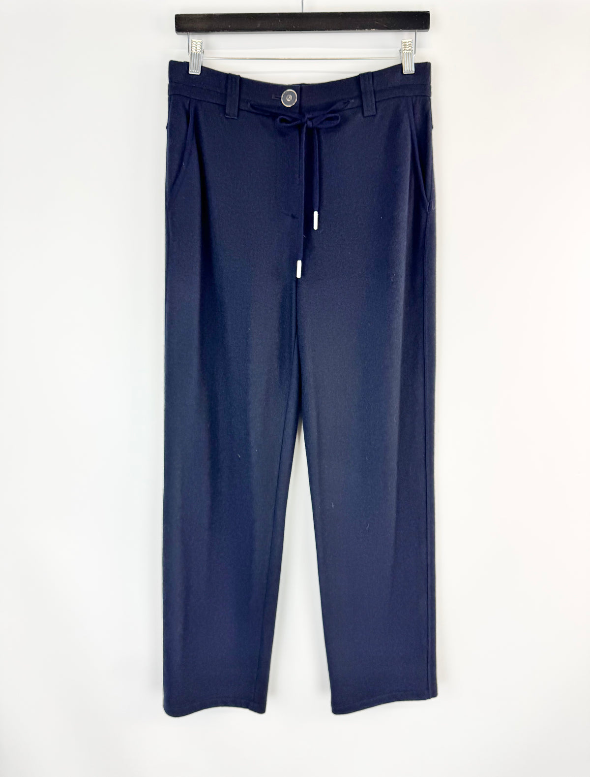 Navy blue pants hanging on a white background