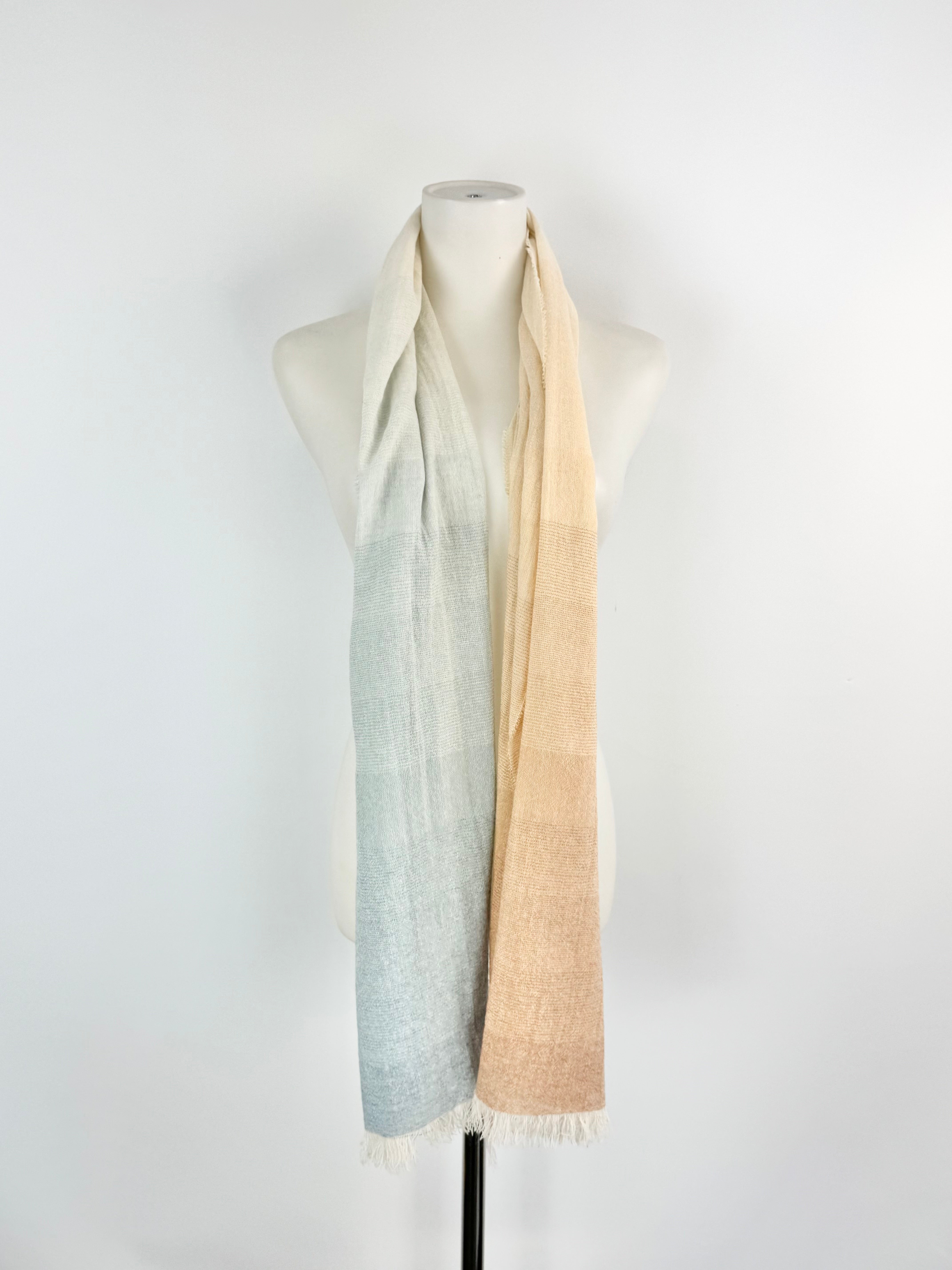 Mannequin wearing a scarf with a gradient from light blue to beige on a white background