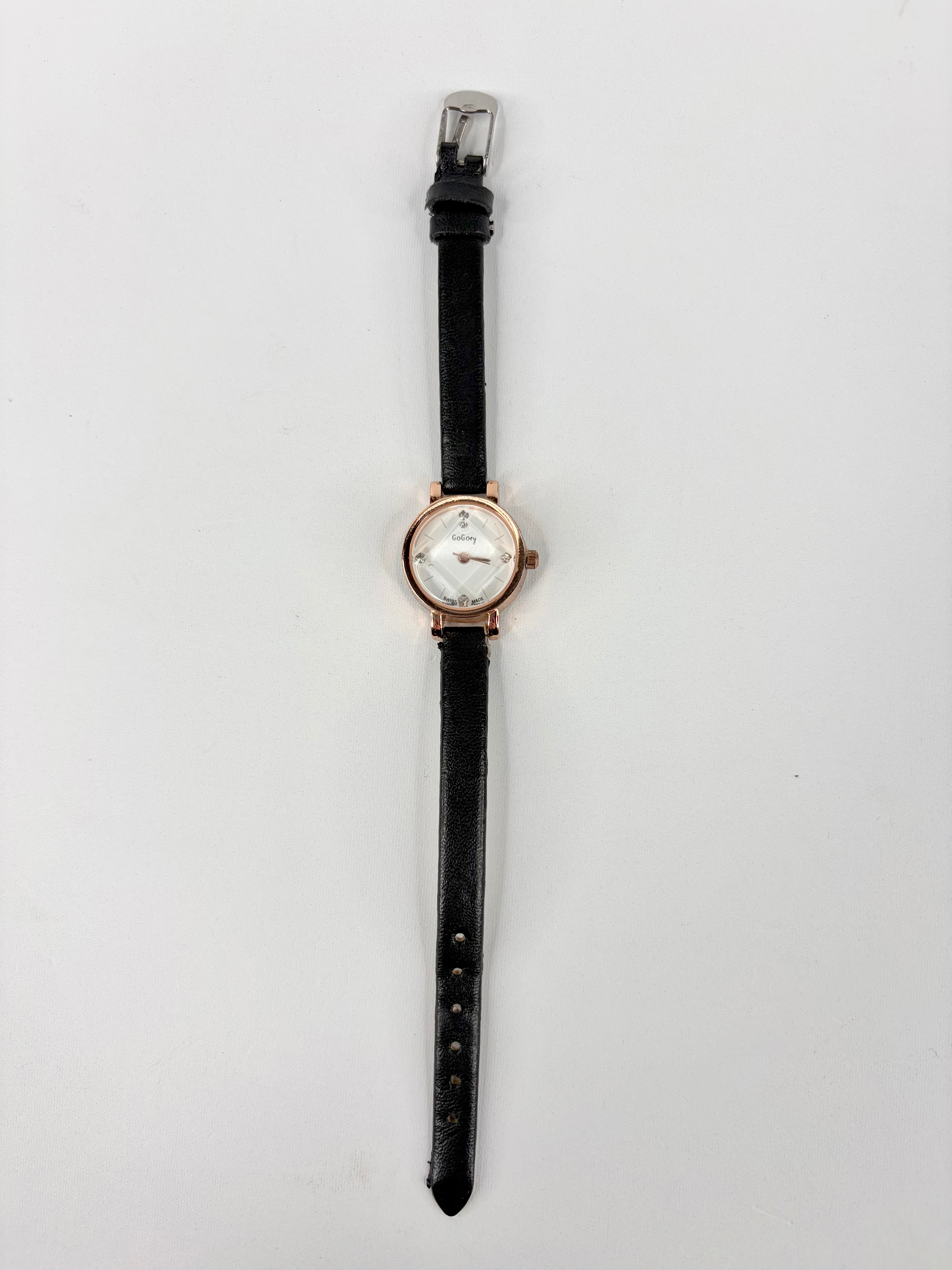 Wristwatch with black strap and rose gold case on a white background