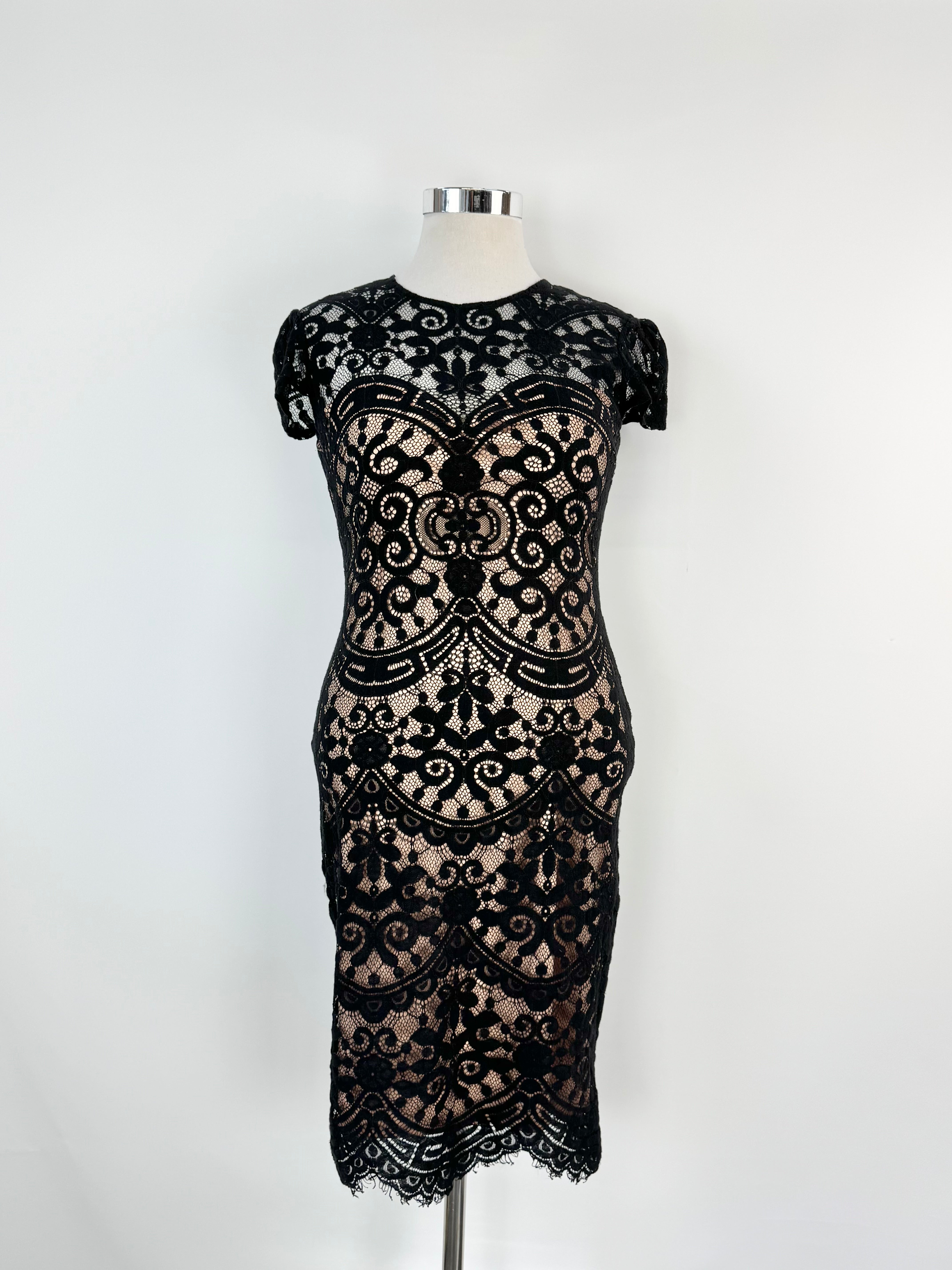 Black lace dress on a mannequin against a white background