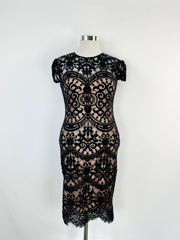 Black lace dress on a mannequin against a white background