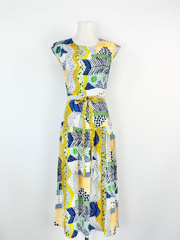 Colourful patterned dress on a mannequin against a white background
