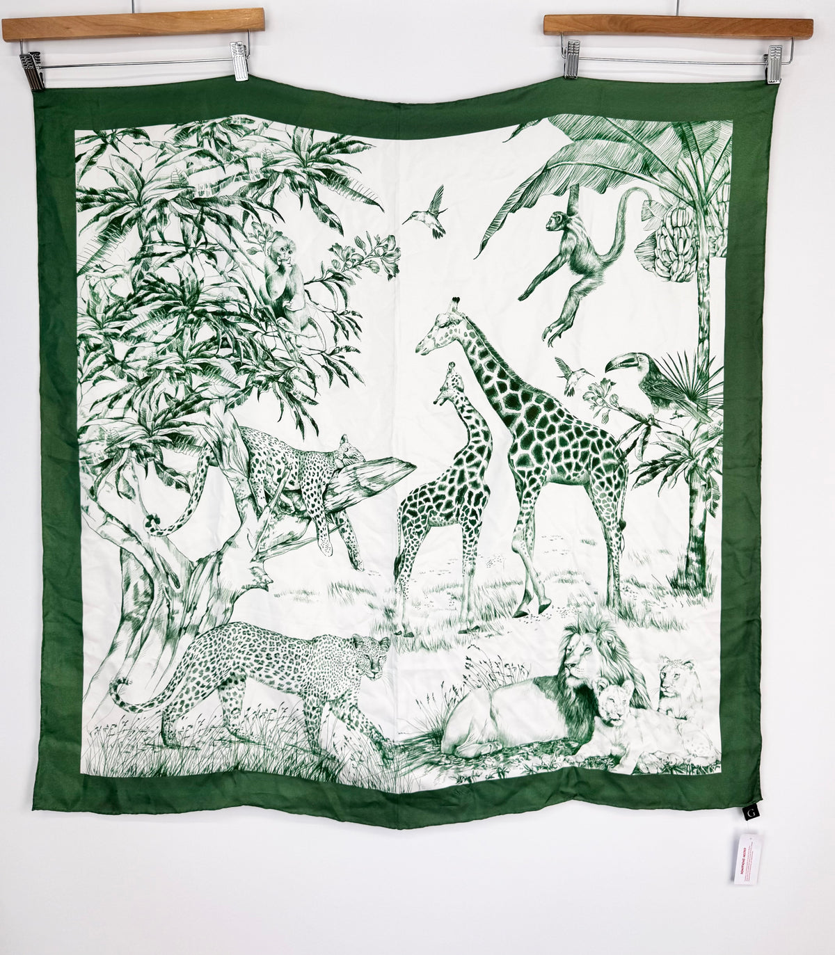 Scarf with green border and black and white animal pattern on a white background
