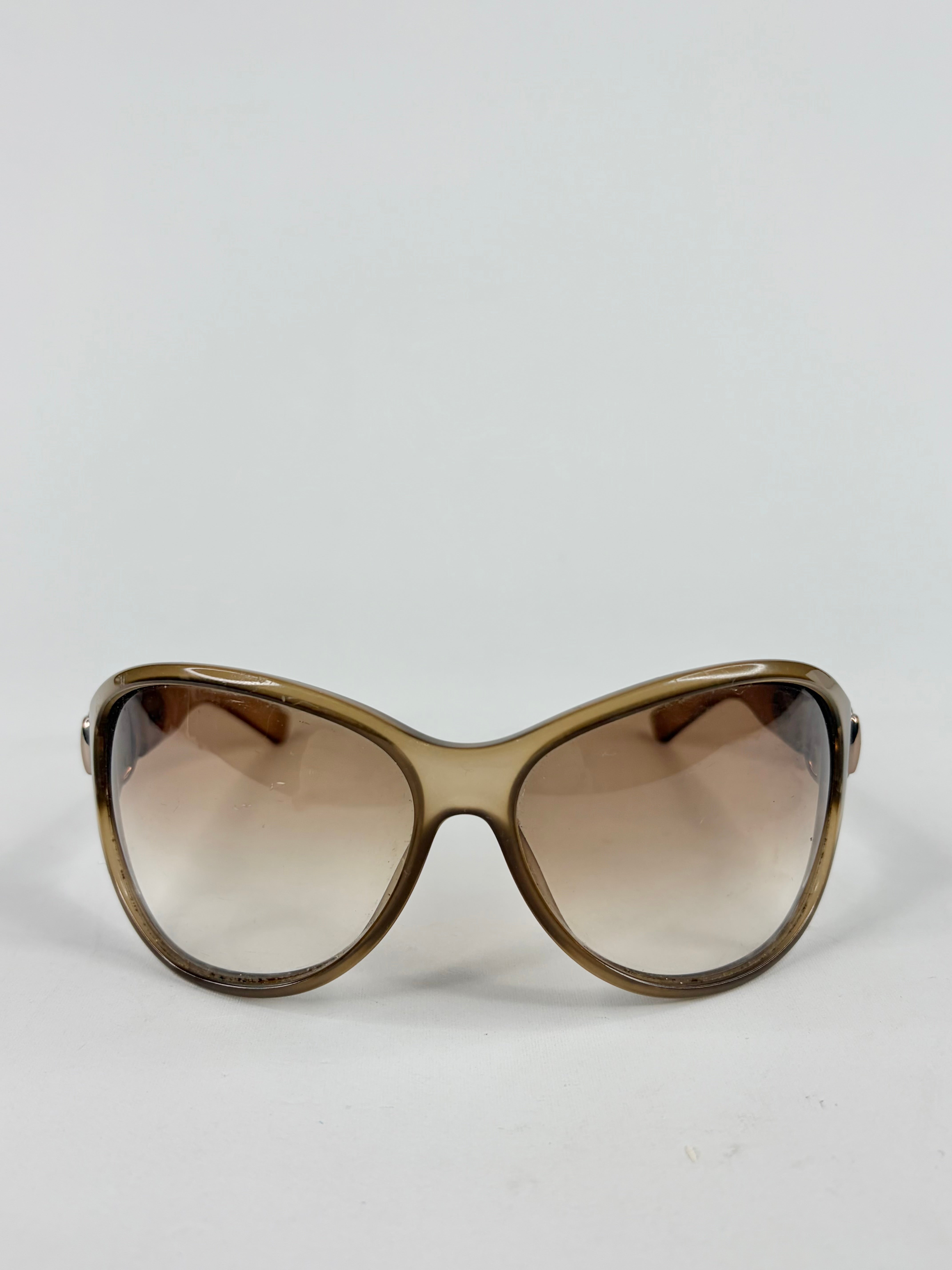 Sunglasses with brown gradient lenses on a light gray background